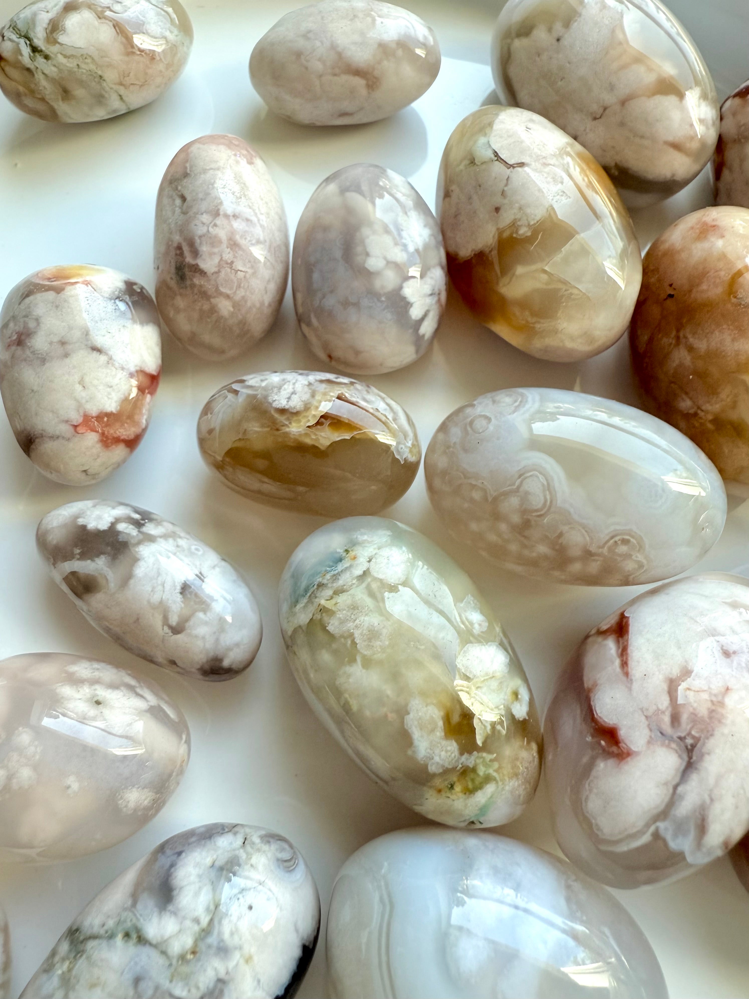 Close up of high quality Flower Agate tumbled stones with beautiful pastel colors on a white plate