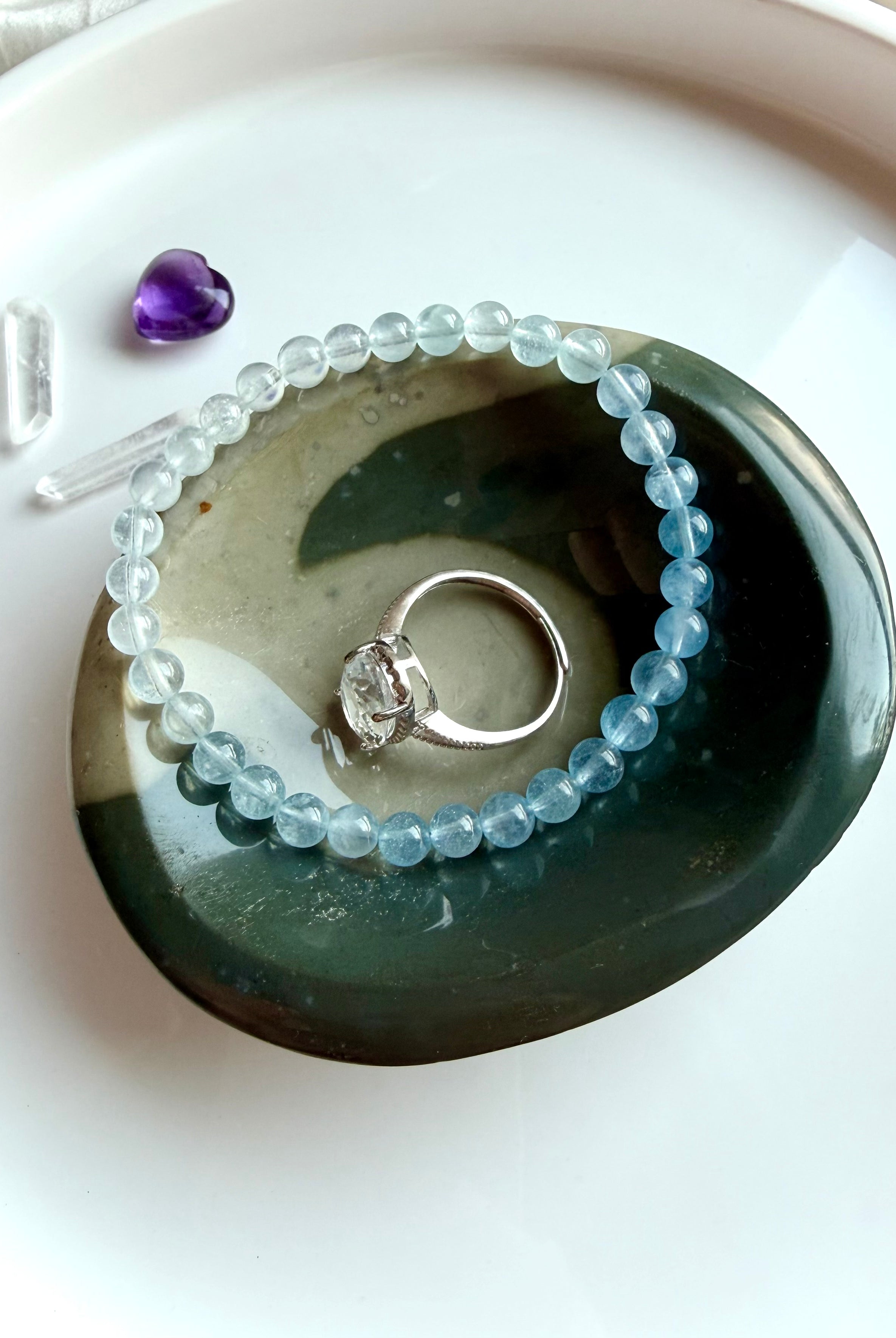 polychrome jasper bowl with natural teal wave pattern holding jewelry rings and crystals