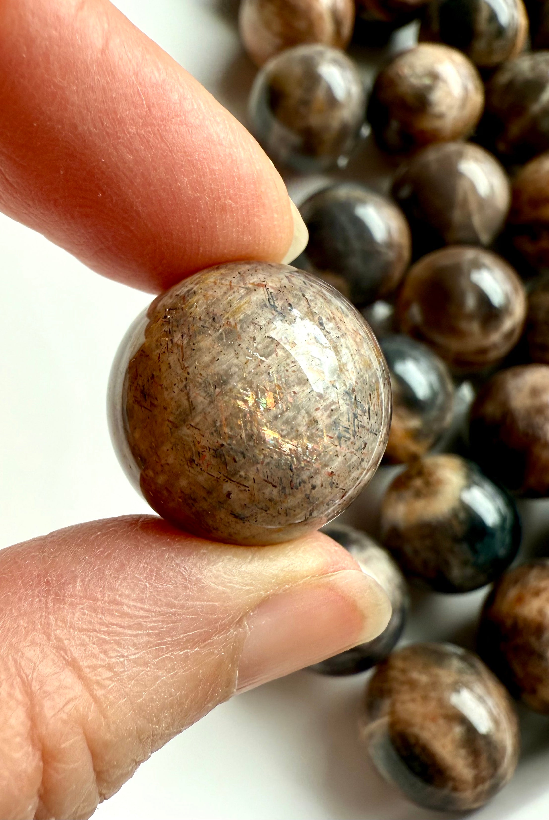 Closeup of Mini Black Moonstone sphere showing sunstone inclusions and shimmer