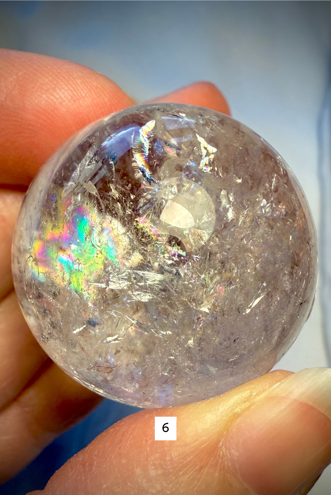 Detailed view of sphere #6 with rainbow shimmer and natural fractures, emphasizing energetic flow and clarity.