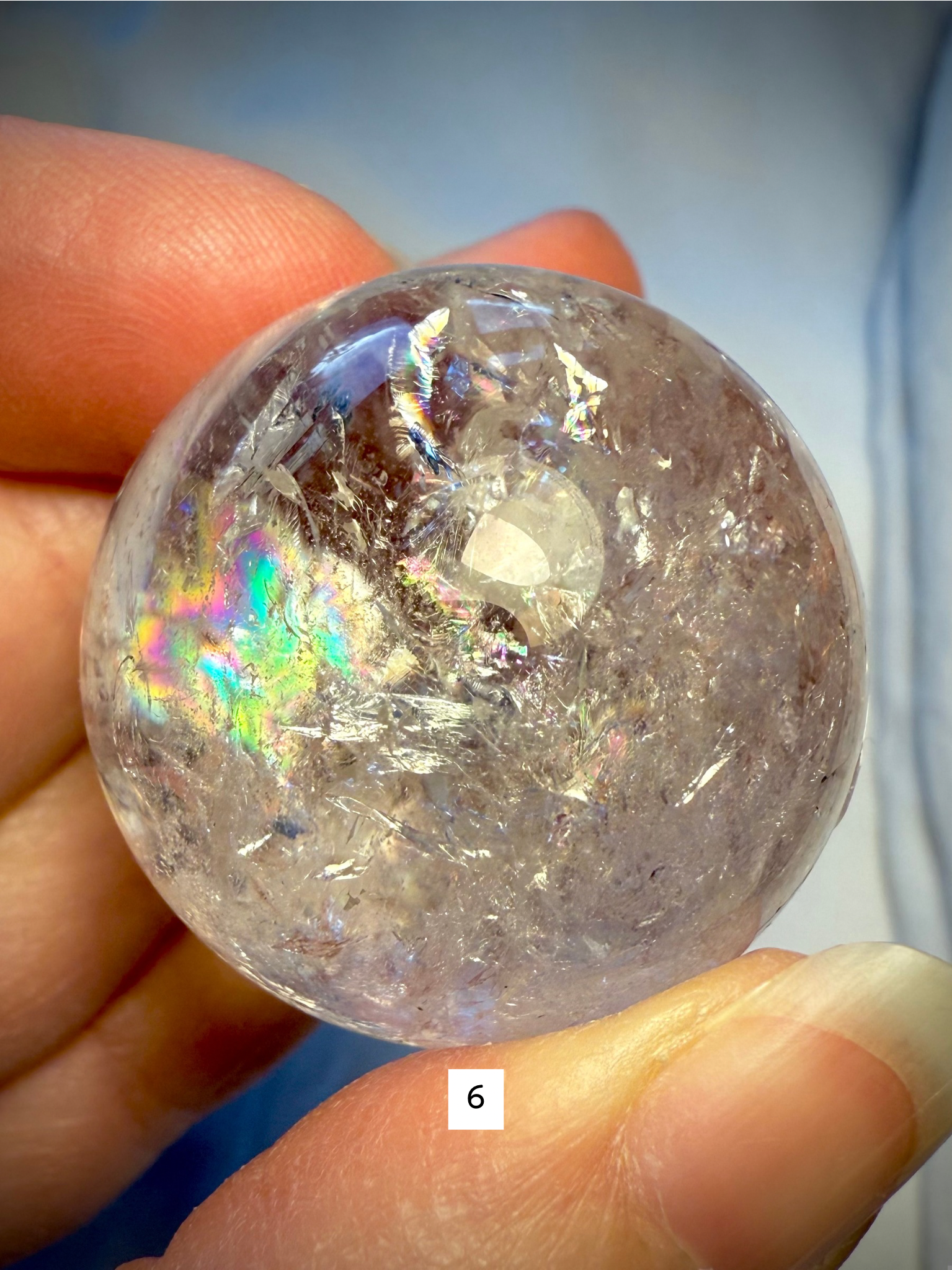 Detailed view of sphere #6 with rainbow shimmer and natural fractures, emphasizing energetic flow and clarity.