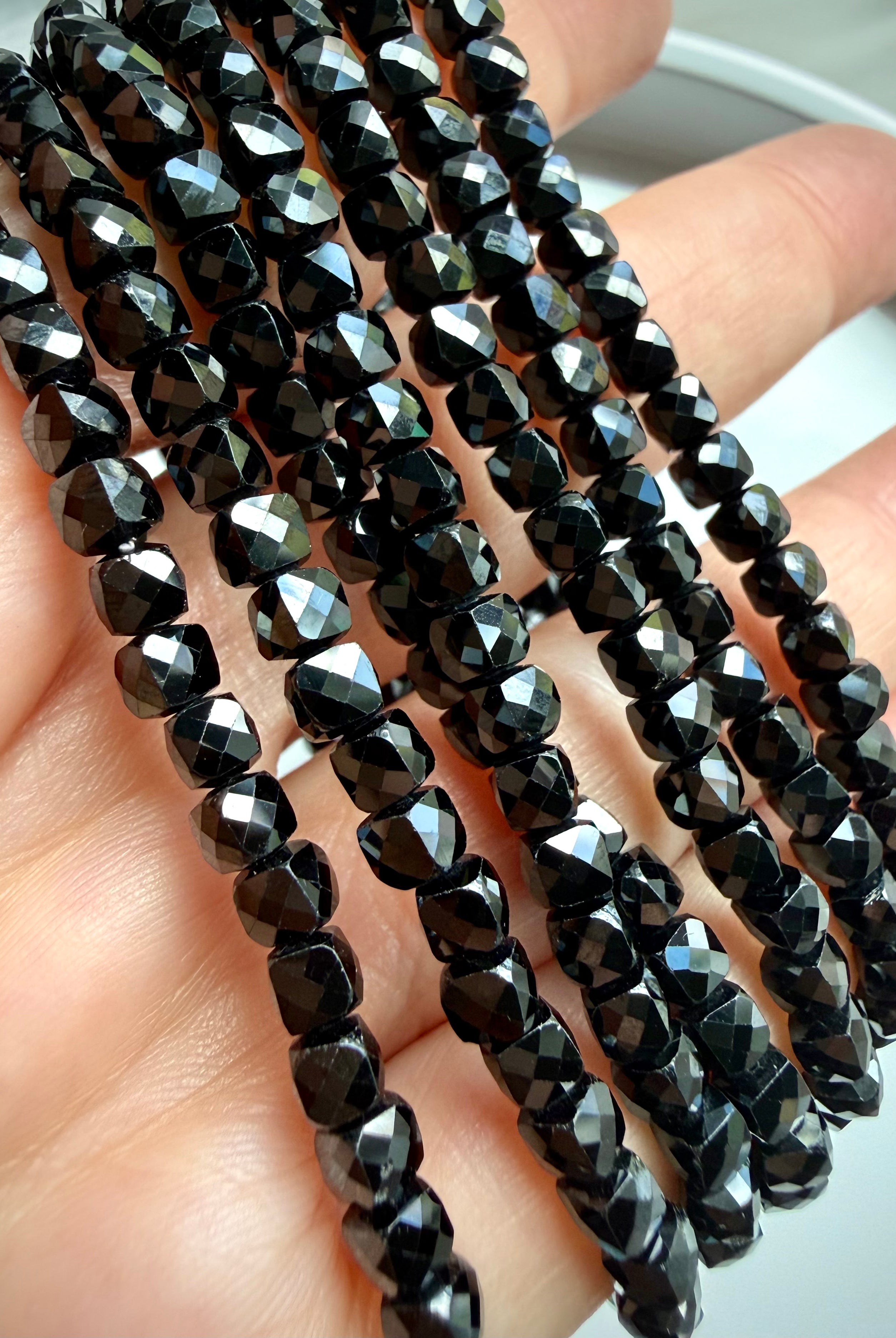 faceted black spinel bracelet strands in hand for protection grounding crystal jewelry