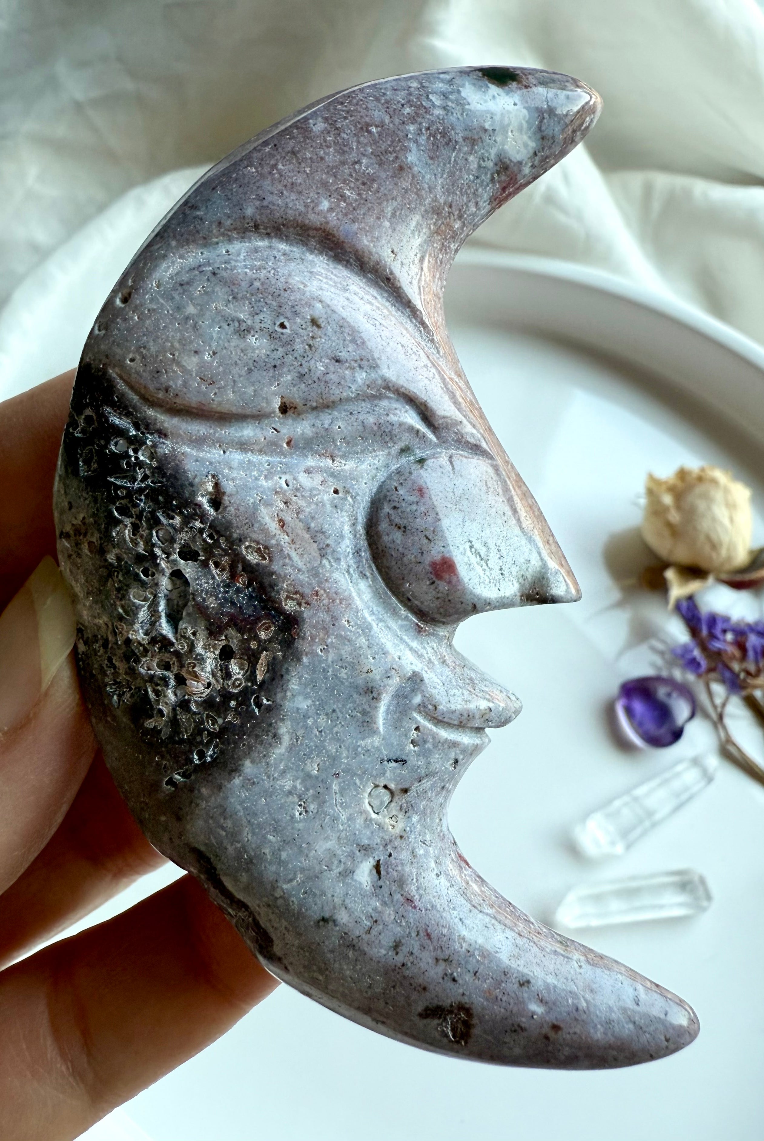 Ocean Jasper moon face carving in purple tones – polished gemstone carving with swirling patterns.