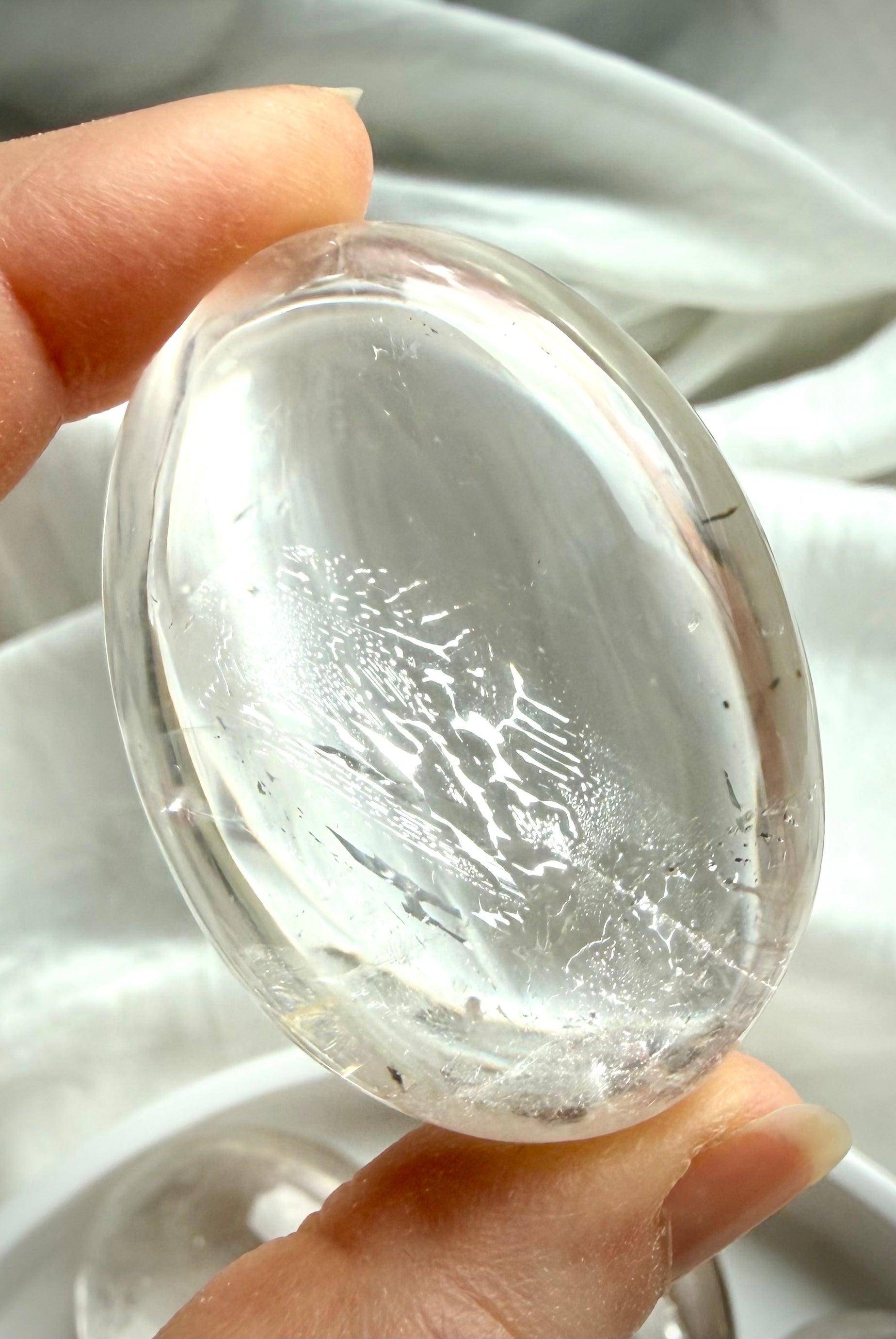 clear quartz palm stone close up with silvery flash and internal veiling