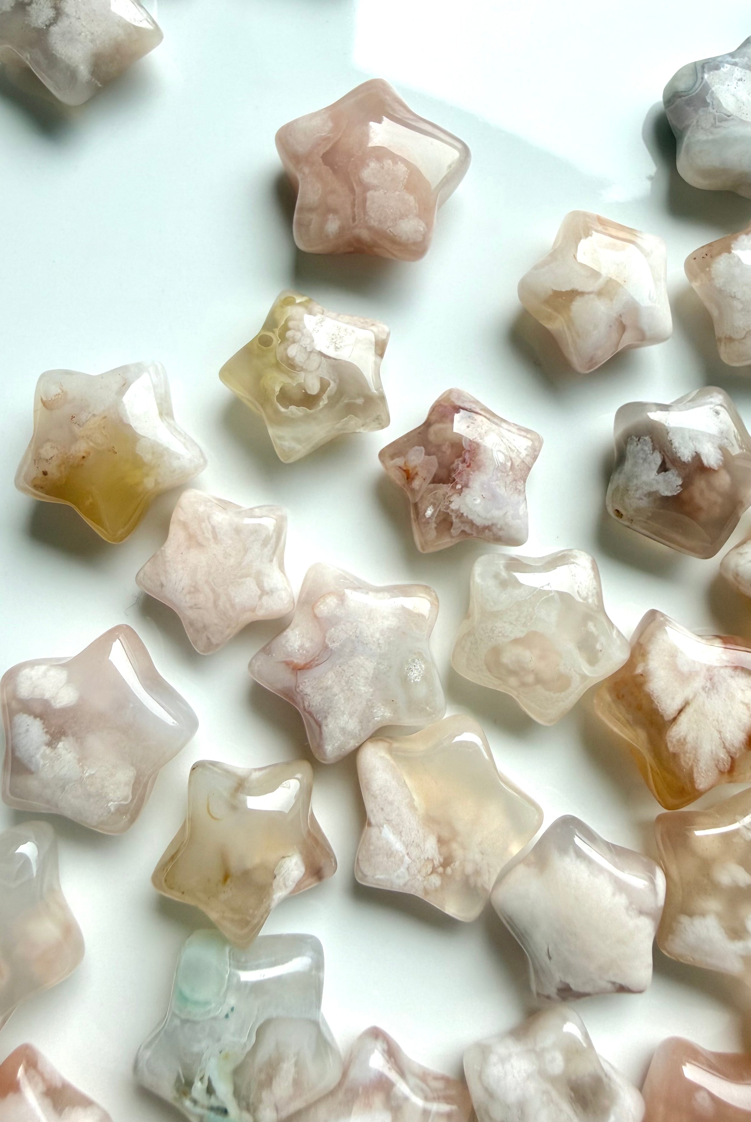 Closeup array of tiny Flower Agate crystal stars with polished finish and blooming floral patterns