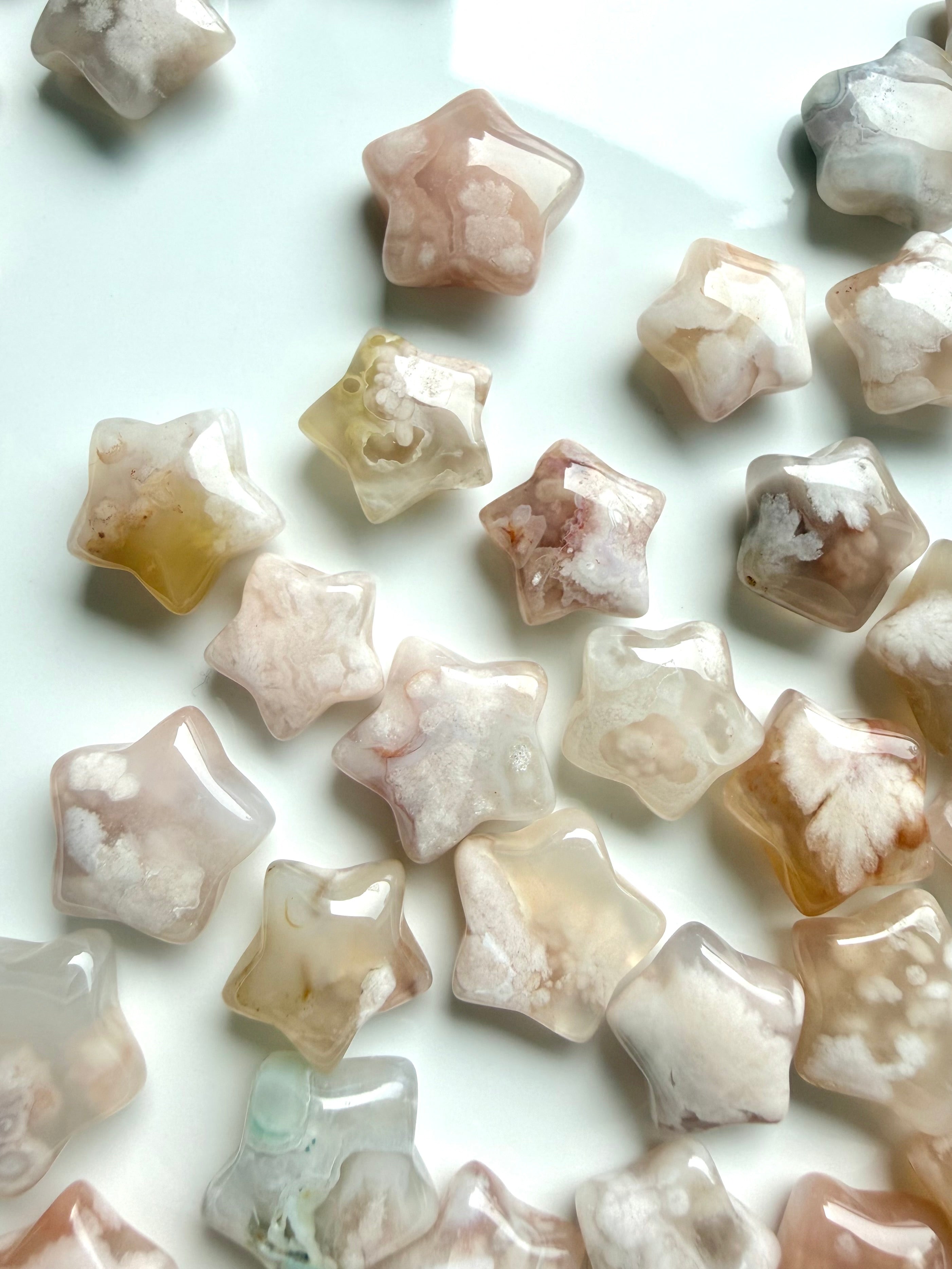 Closeup array of tiny Flower Agate crystal stars with polished finish and blooming floral patterns