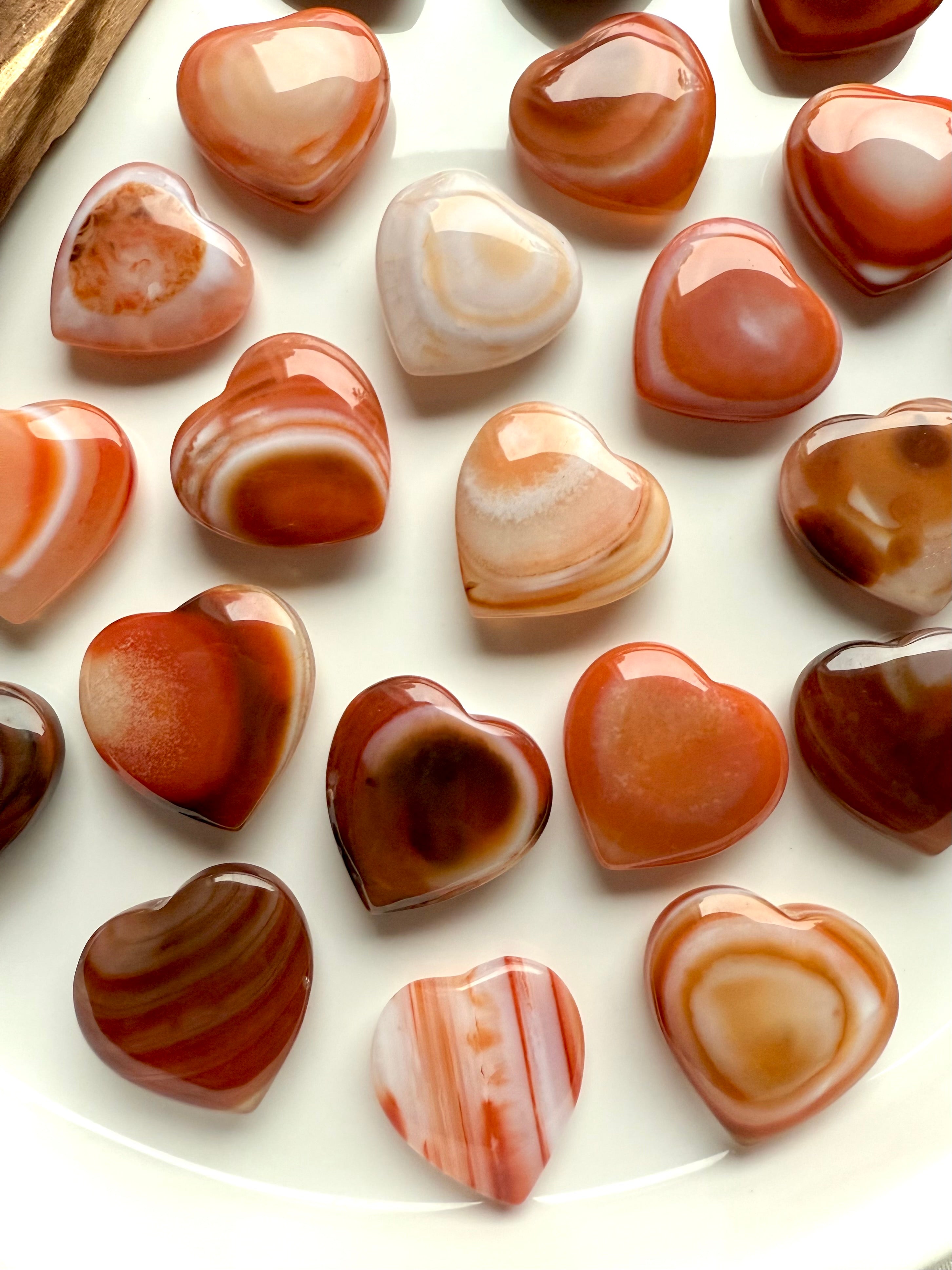 Overhead view of Mini Carnelian Hearts with unique patterns, Sacral Chakra crystals for motivation and inspired action