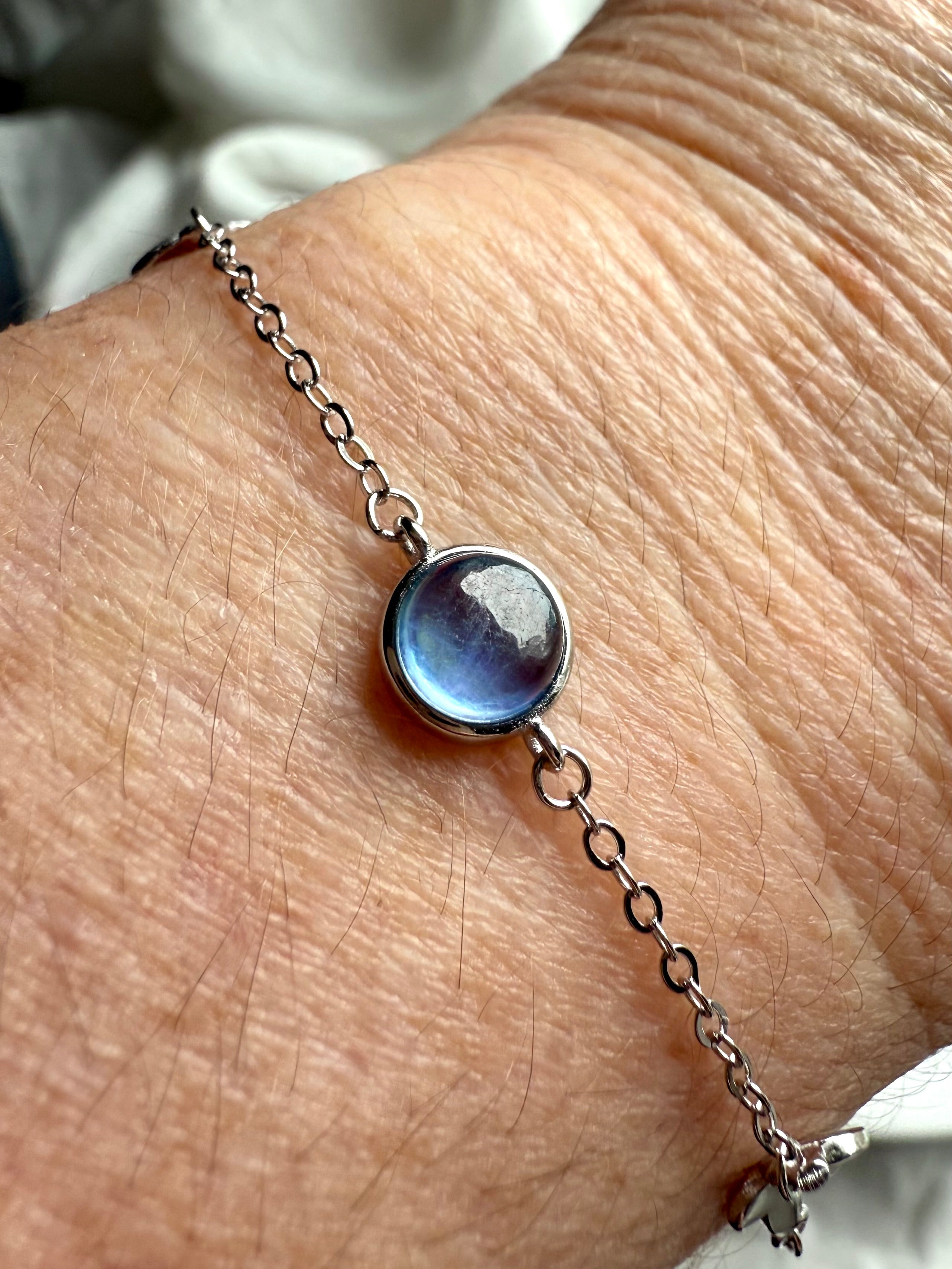 Close-up of sterling silver aquamarine bracelet on wrist, handmade gemstone jewelry for peace, clarity, and emotional balance