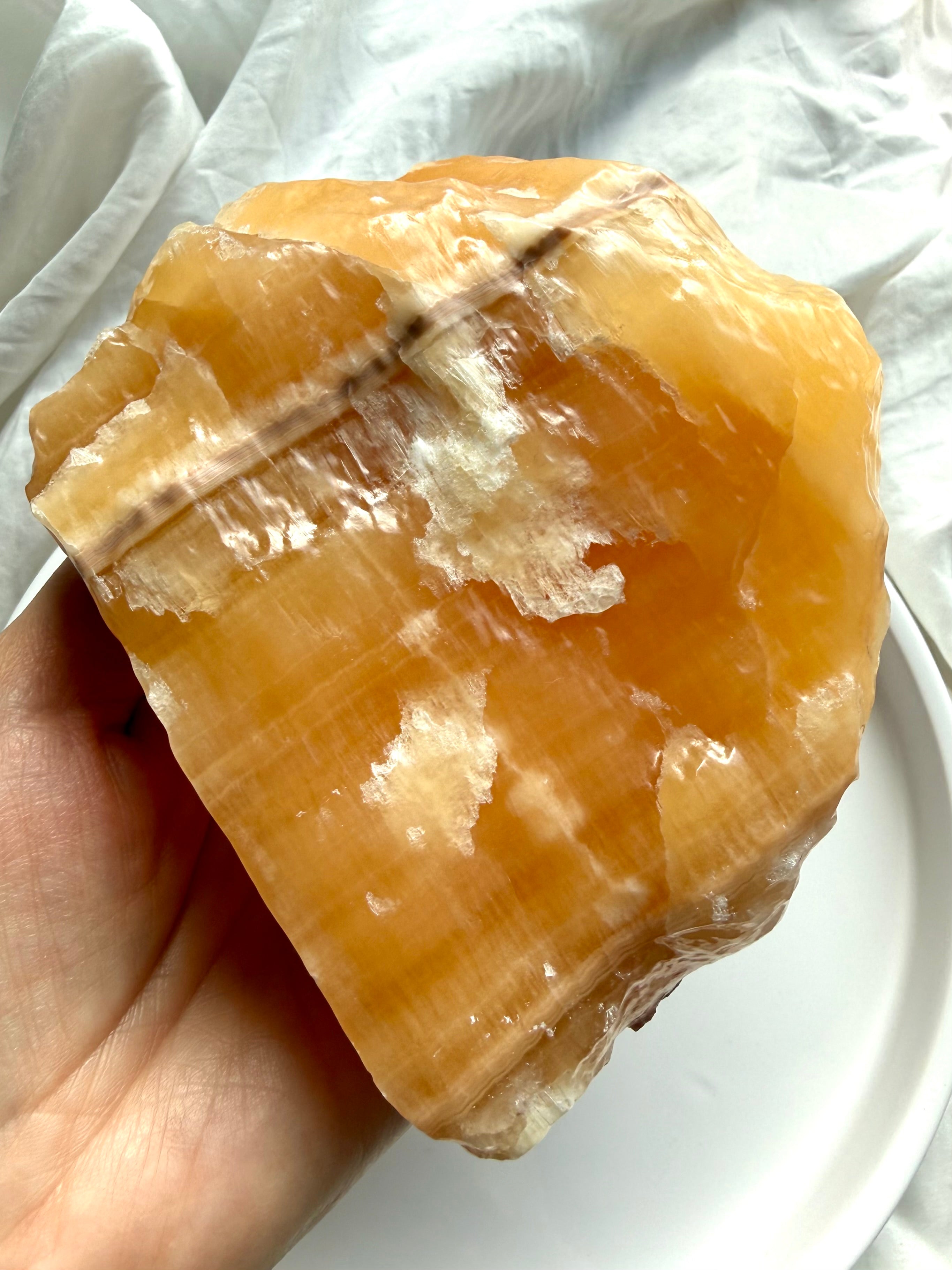 Large Orange Calcite mineral display specimen with natural texture, white calcite formations, and warm orange glow