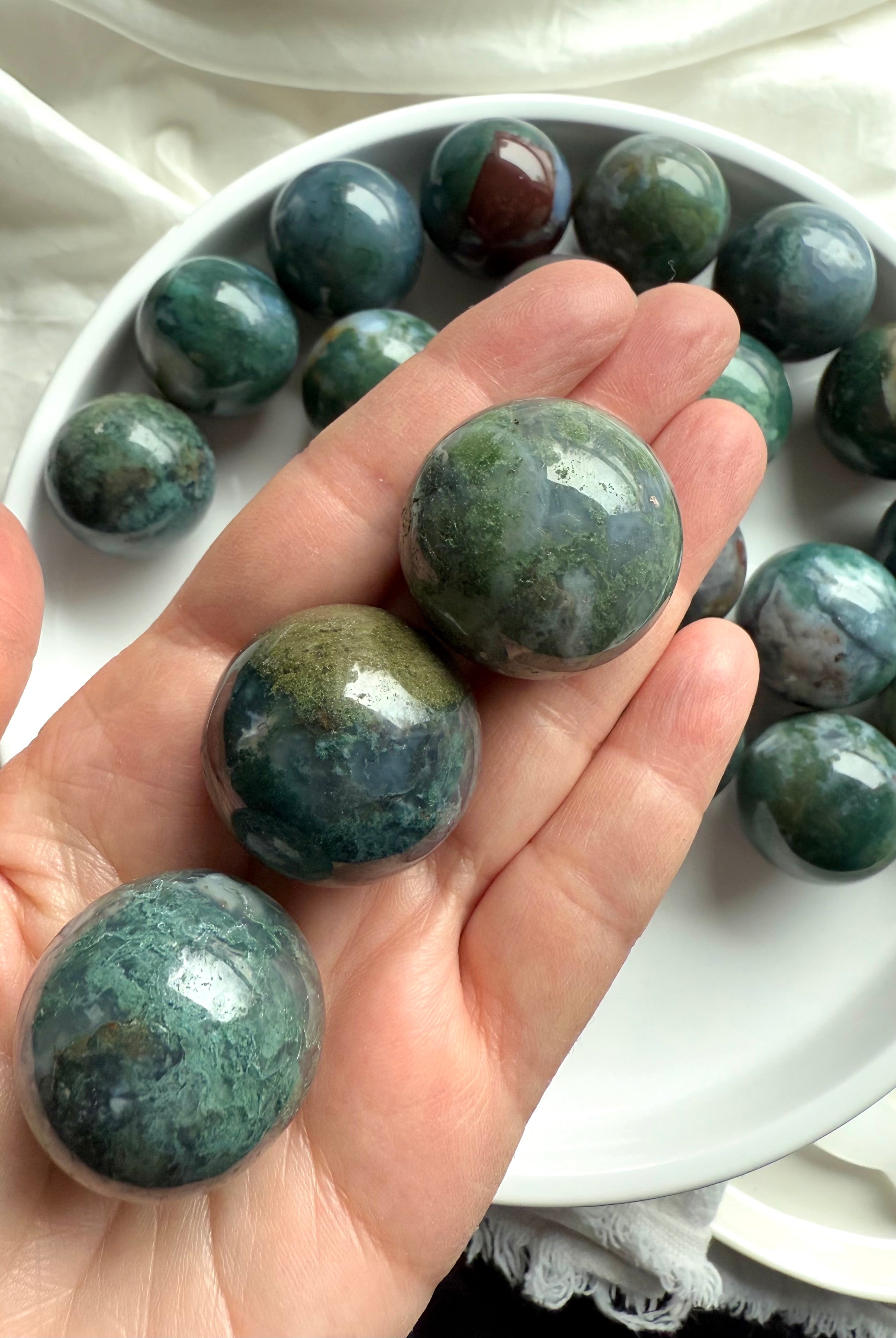 Colorful moss agate mini spheres shown on my hand