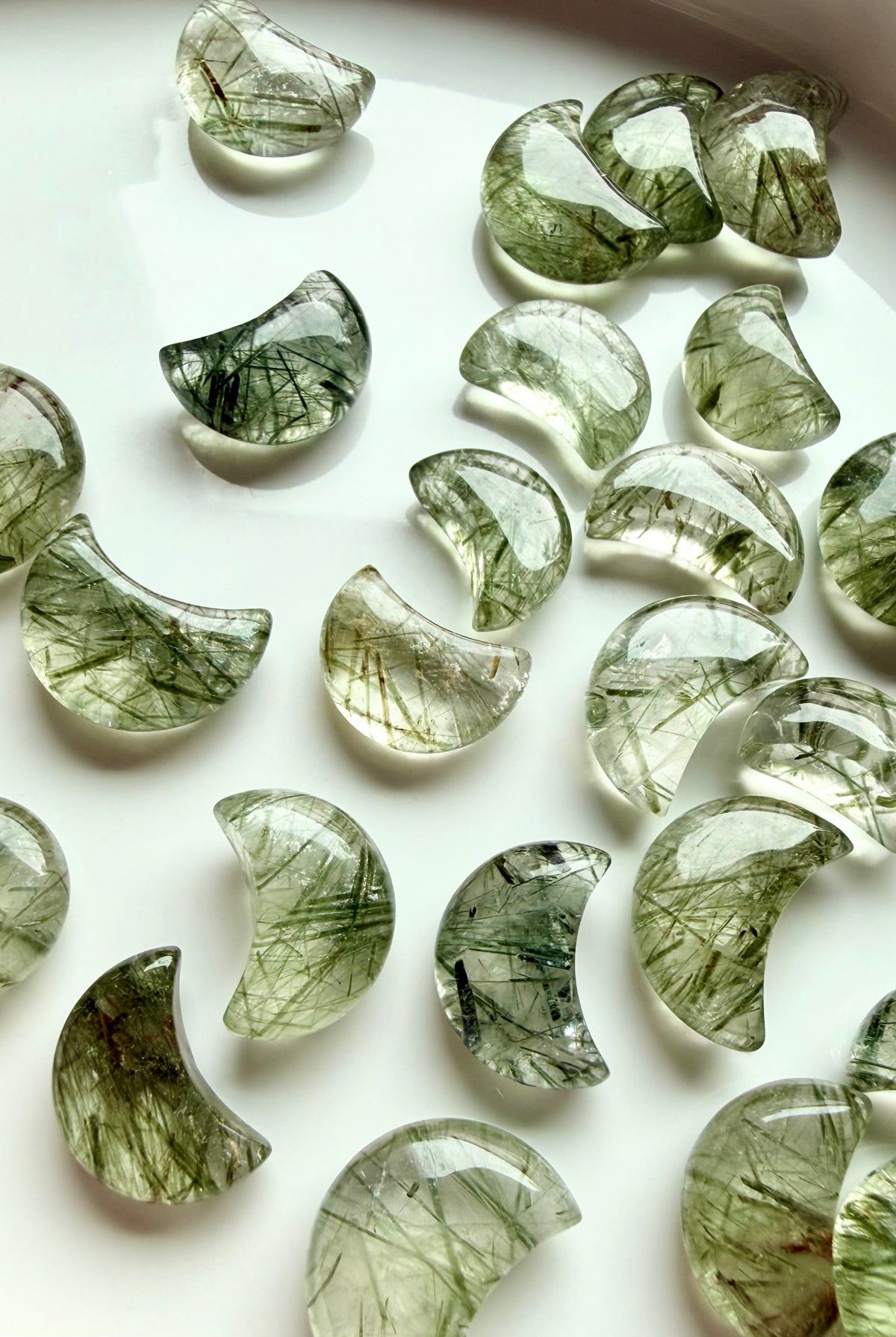 Green Tourmaline Quartz moon carvings showing variations in translucence, green inclusions and natural crystal patterns