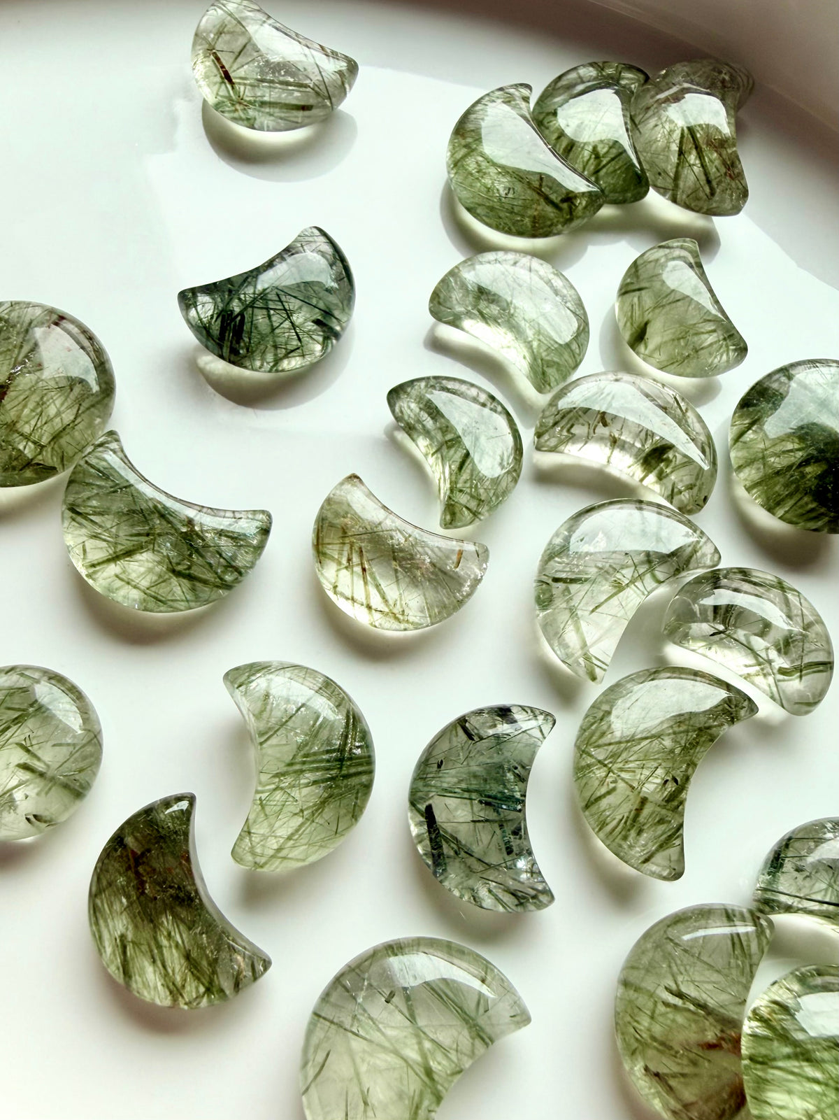 Green Tourmaline Quartz moon carvings showing variations in translucence, green inclusions and natural crystal patterns