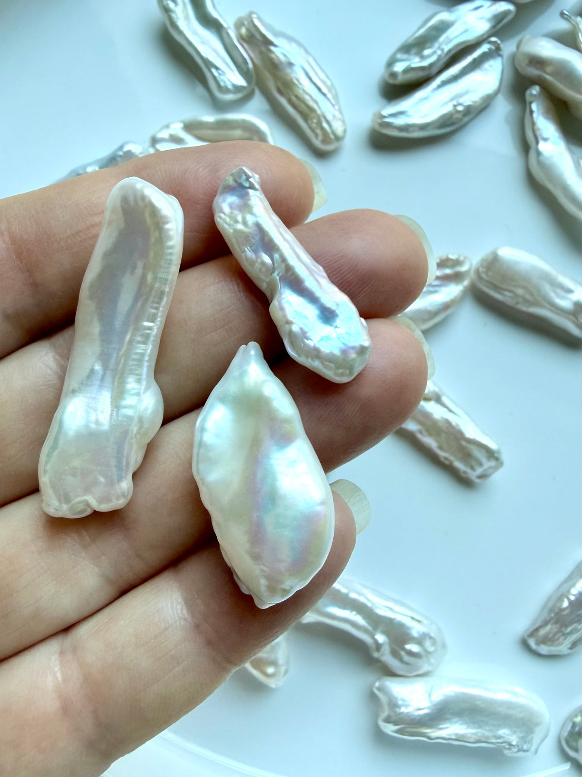 Closeup of undrilled Baroque Stick Pearls held in hand showing natural size, shape & pearlescent luster