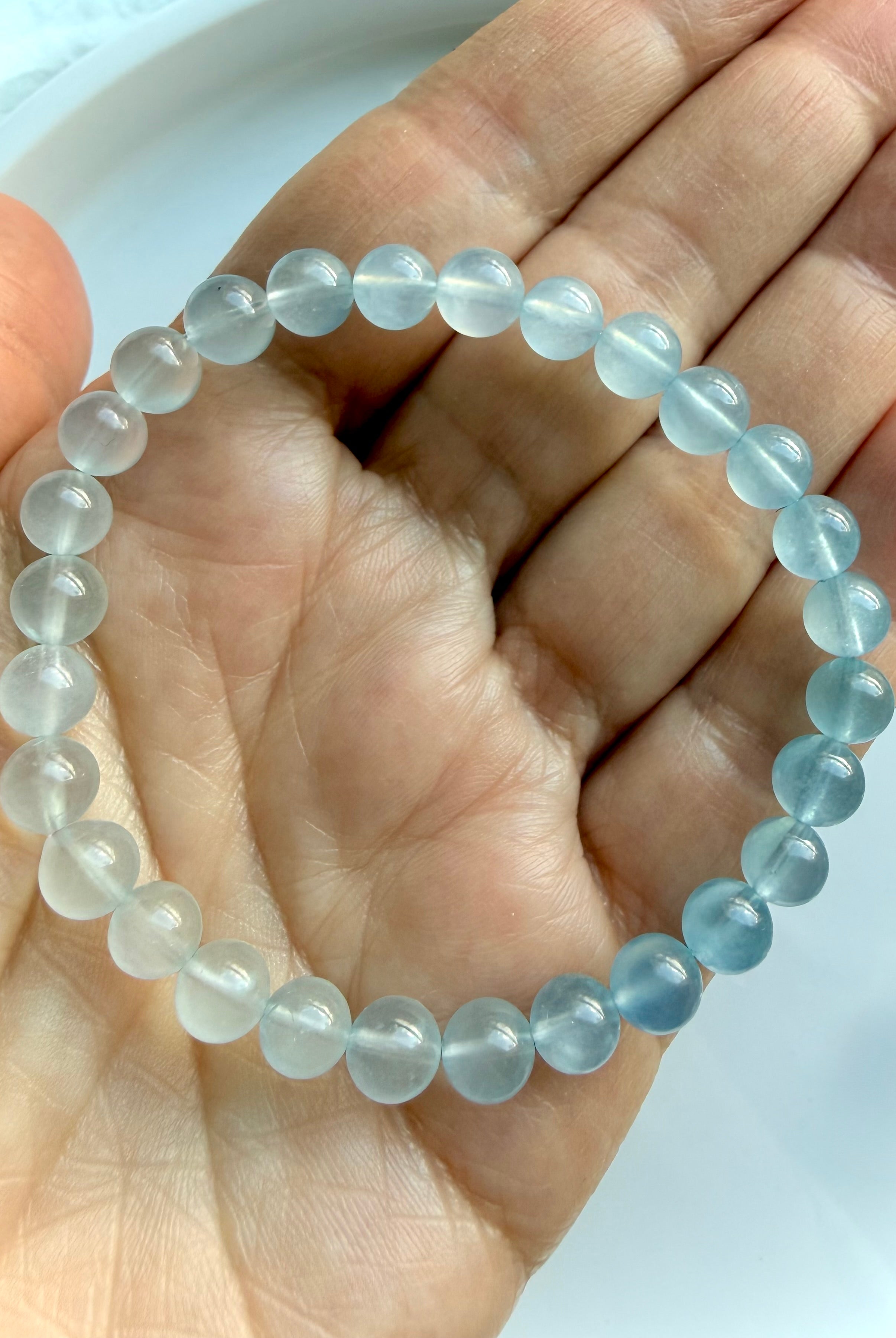 Close up view of March birthstone Aquamarine bracelet in luminous ombré blue gemstone beads