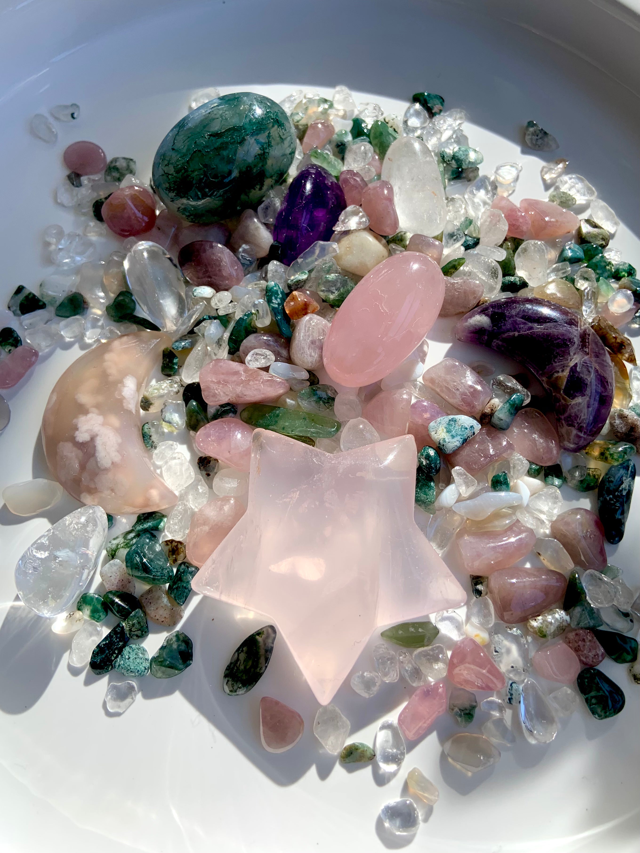 large rose quartz star carving displayed in a bowl of mixed healing crystals for heart chakra décor and gifting