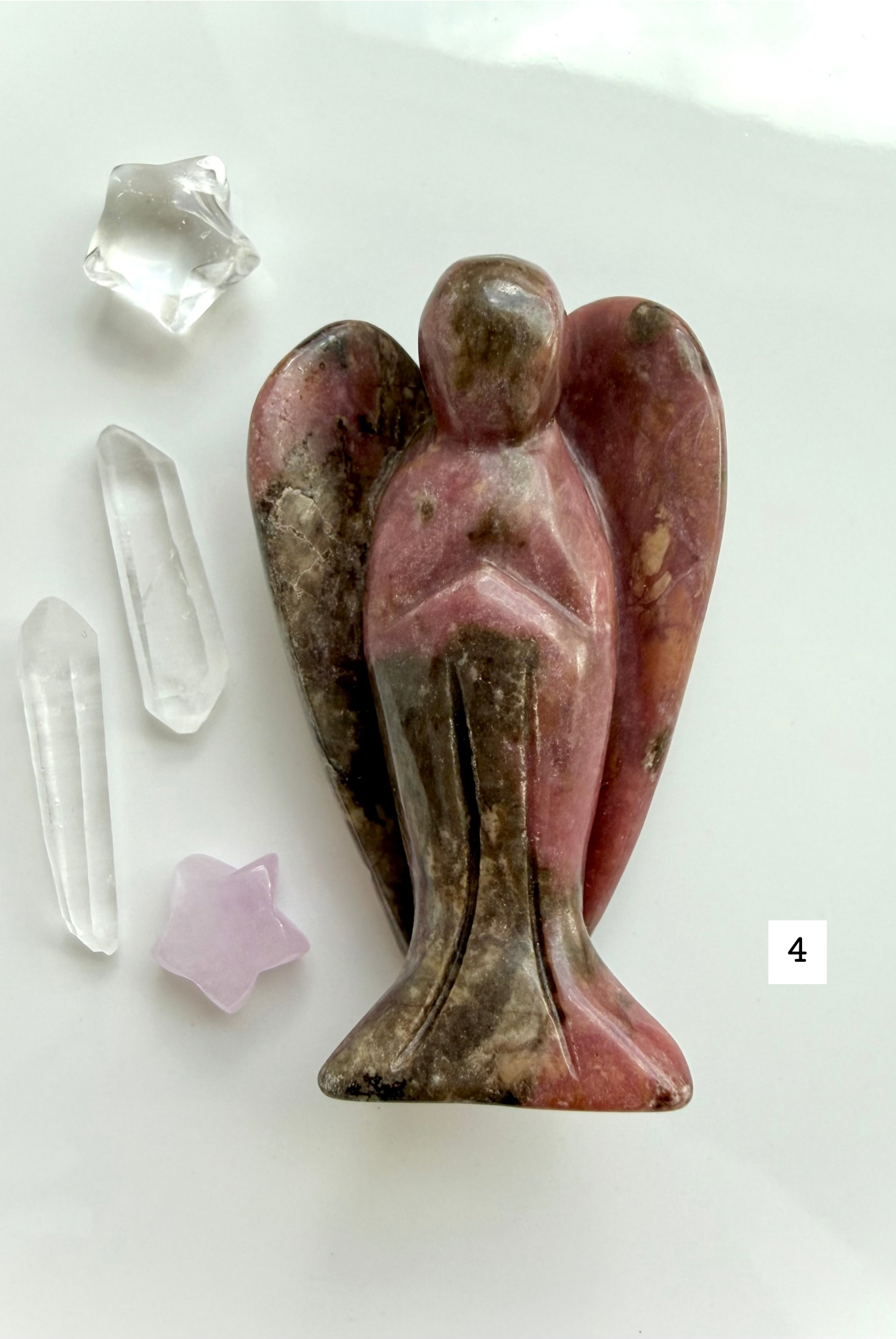 Rhodonite angel carving with bold black inclusions and pink matrix for love and protection
