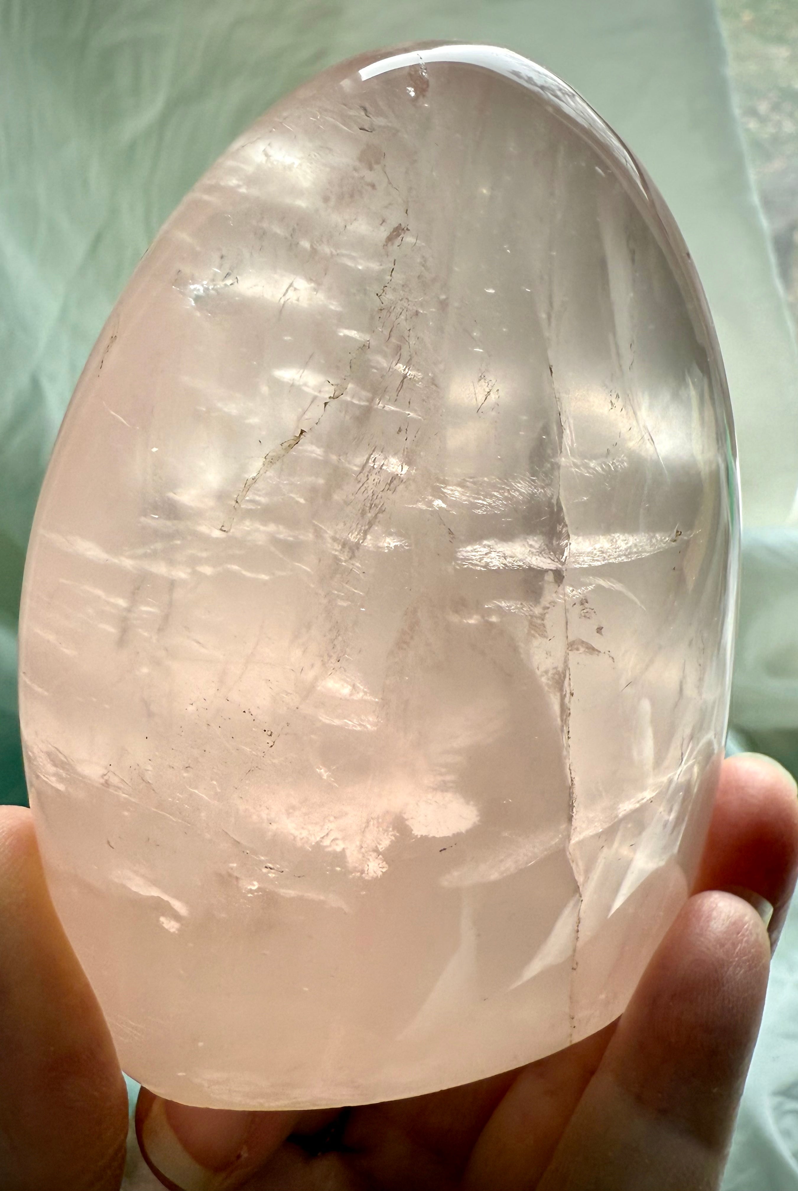 Polished Rose Quartz freeform crystal with luminous blush pink color and glowing internal light