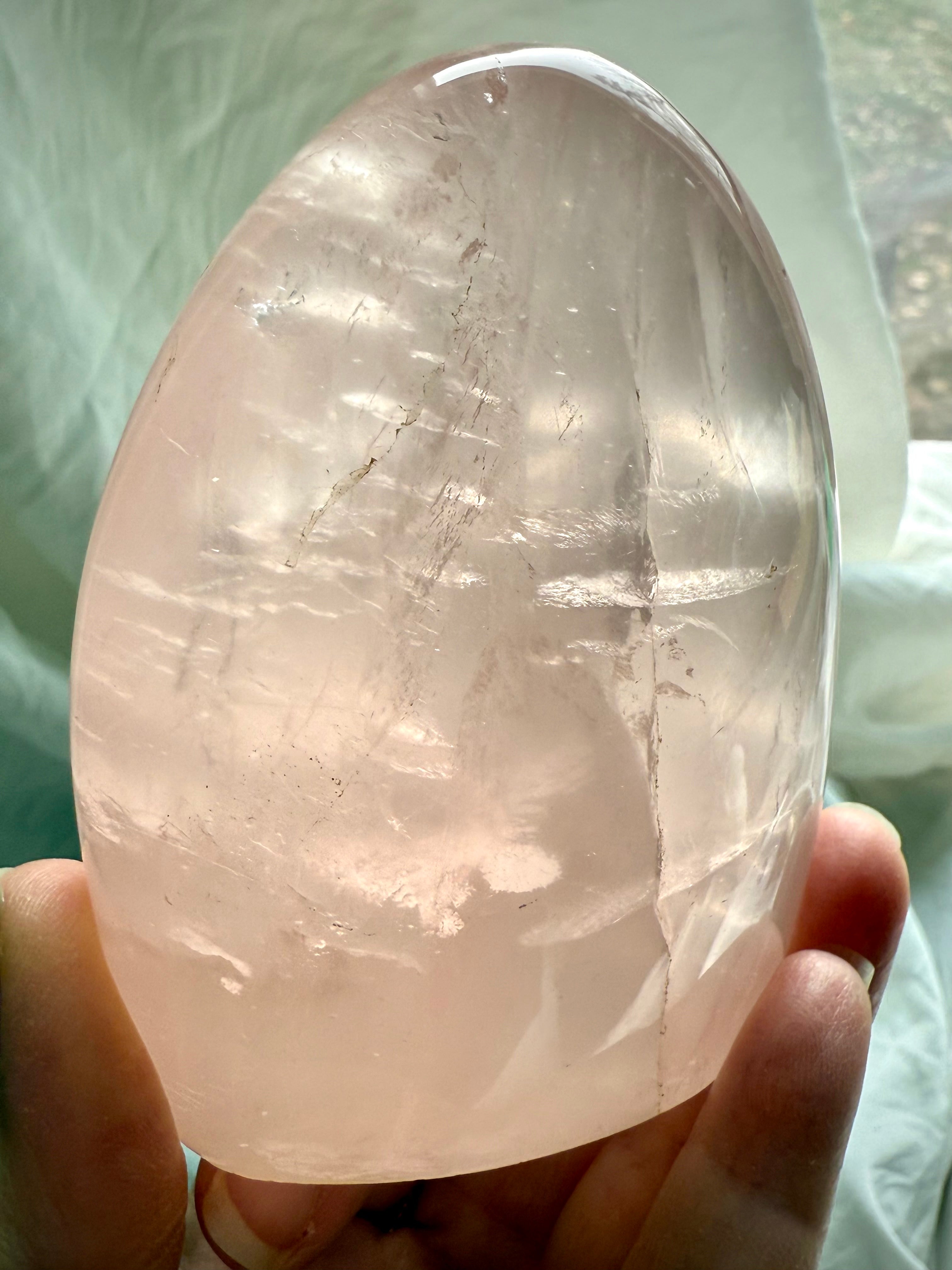 Polished Rose Quartz freeform crystal with luminous blush pink color and glowing internal light