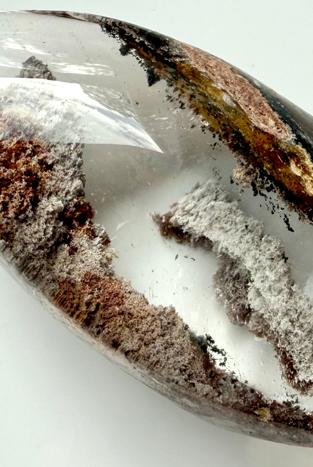 Close-up of Garden Quartz phantom layers with mossy green and rusty mineral inclusions