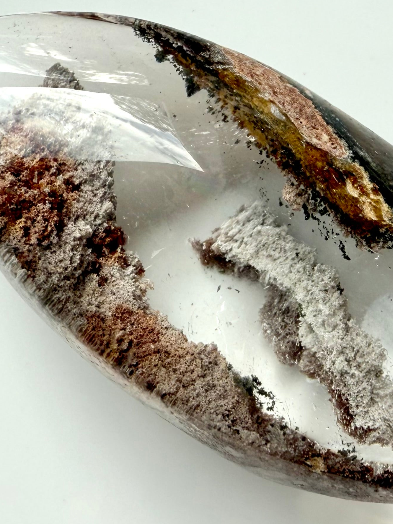 Close-up of Garden Quartz phantom layers with mossy green and rusty mineral inclusions