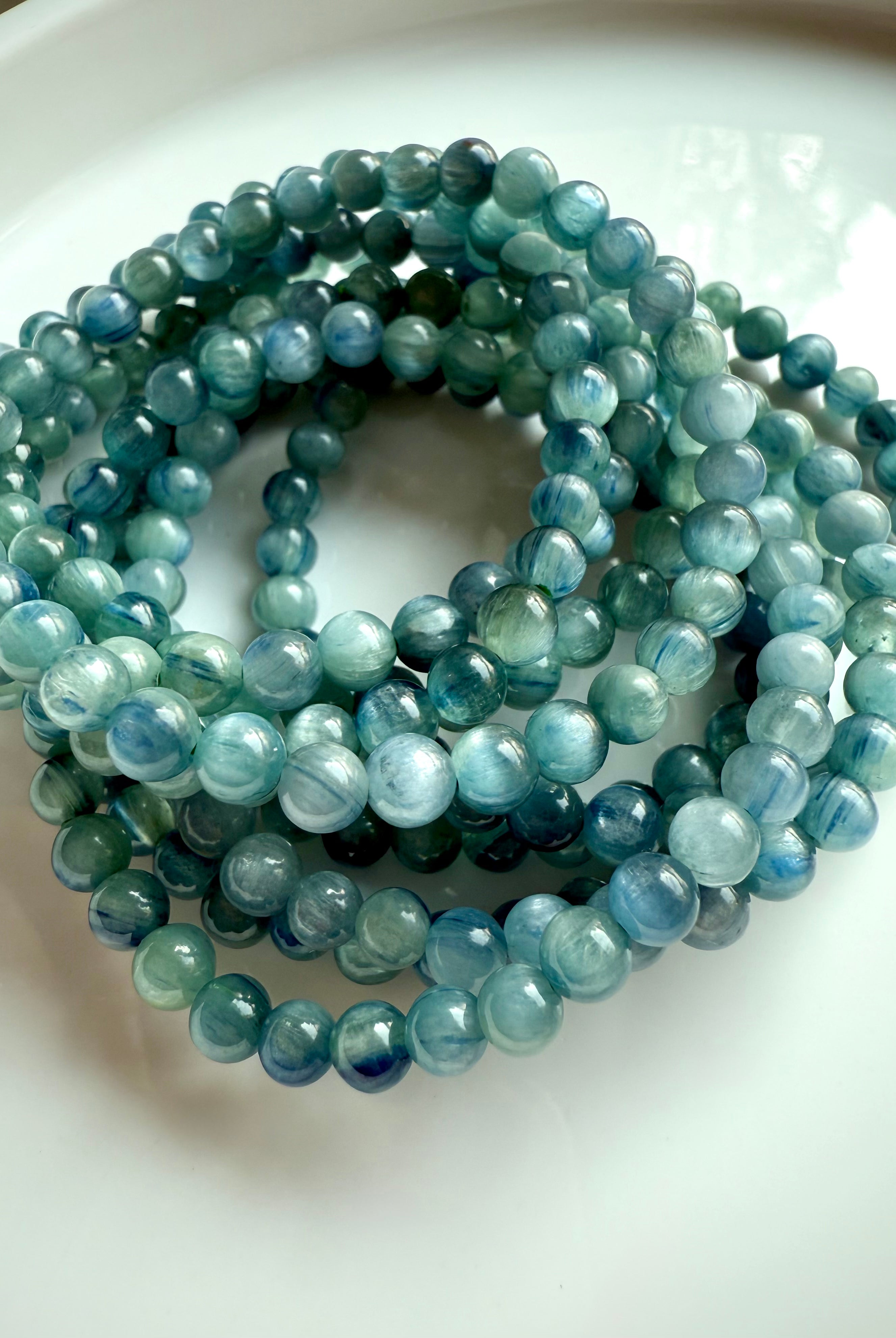 stacked blue-green kyanite bracelets reflecting soft light and color gradients, ideal for gifting or ritual use