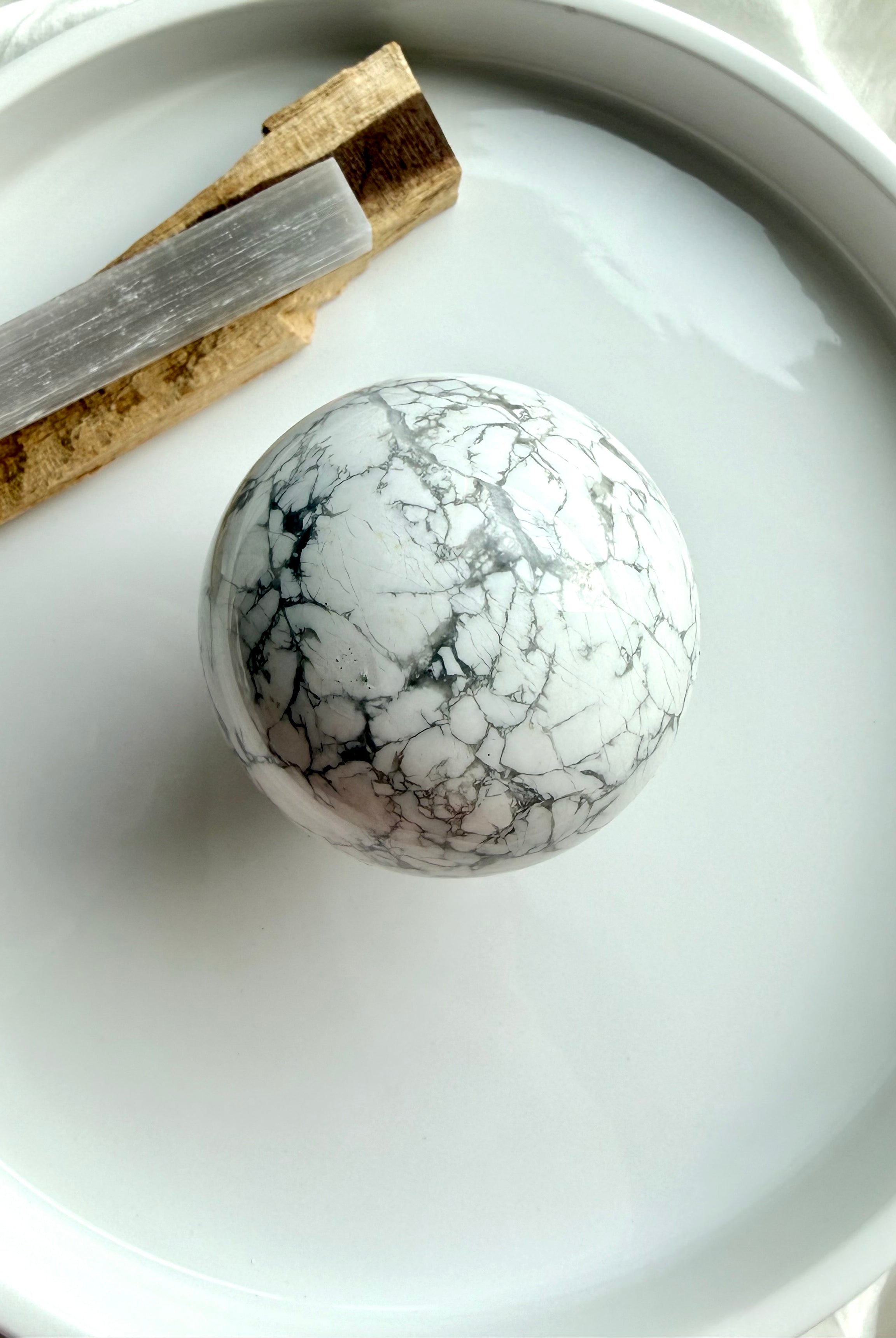 Howlite sphere with palo santo and selenite on white tray, calming crystal ball for meditation, sleep support and peaceful energy