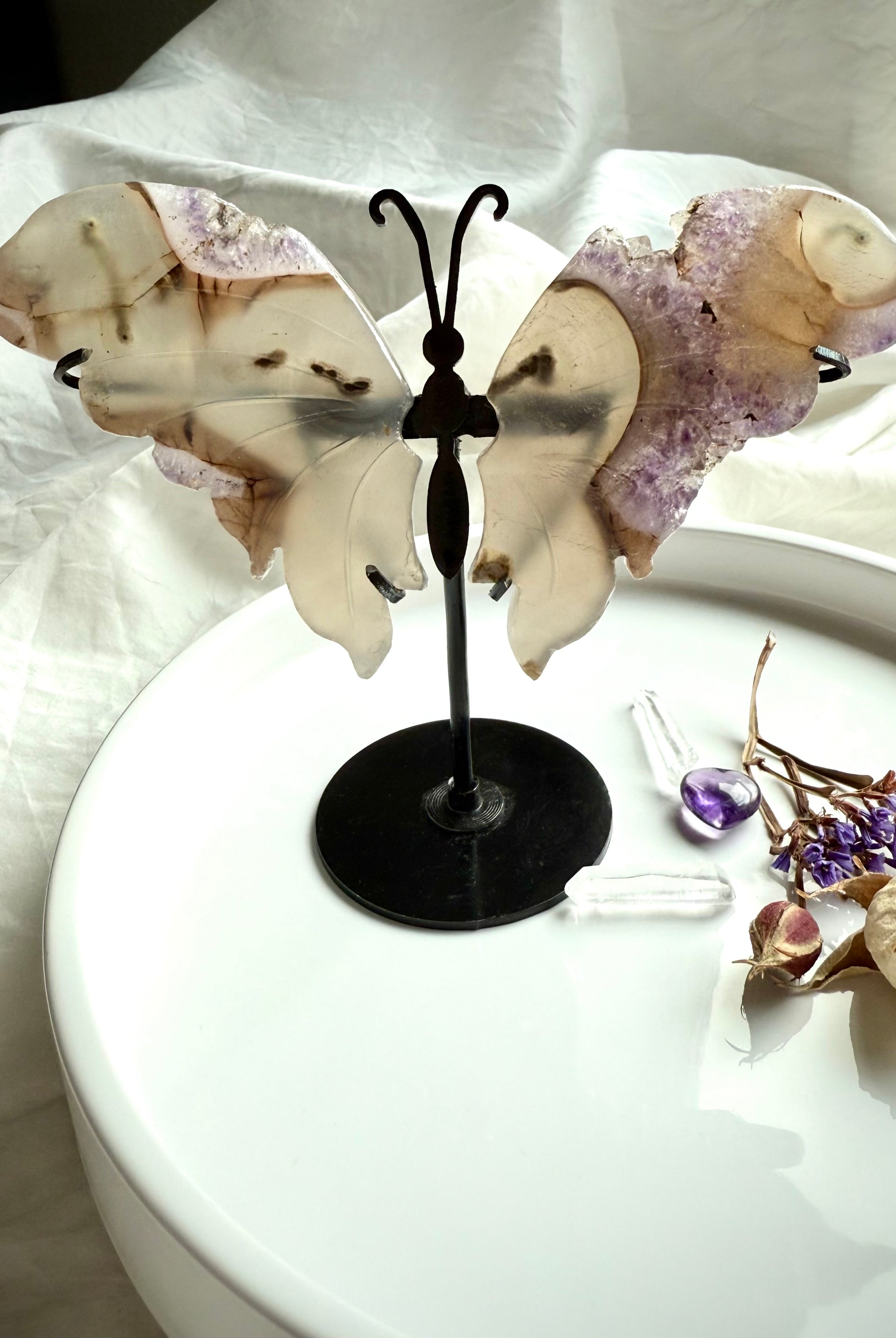 Amethyst druzy and agate butterfly wings displayed on metal stand, shimmering lavender crystals and earthy agate banding for altar décor and spiritual transformation.