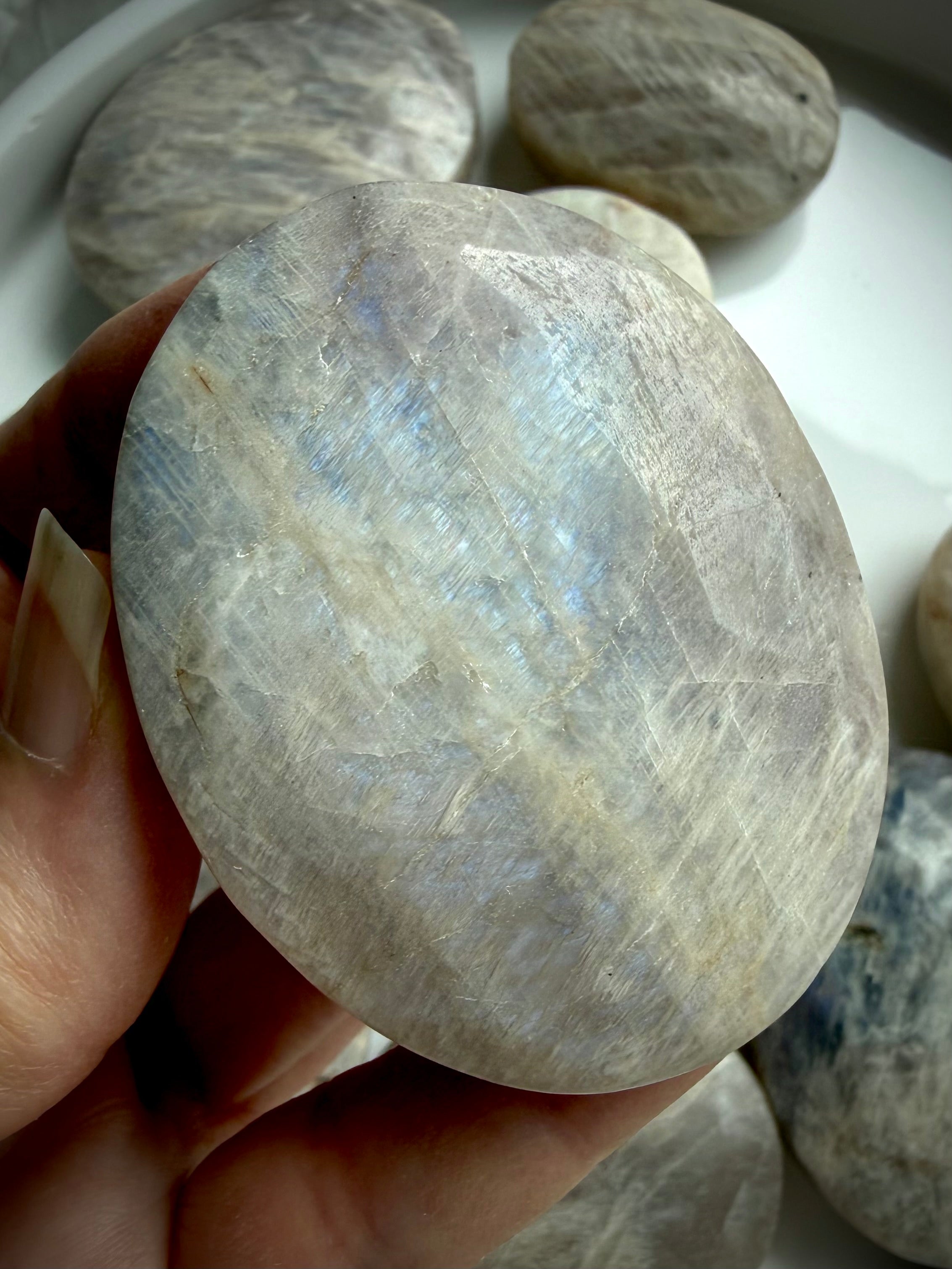 high flash belomorite moonstone palm stone with blue shimmer and natural mineral inclusions