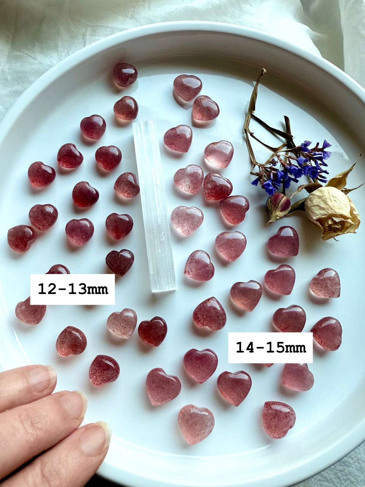 Array of Strawberry Quartz mini hearts on a white plate — tanzberry quartz crystals for heart chakra healing, love, and emotional balance.