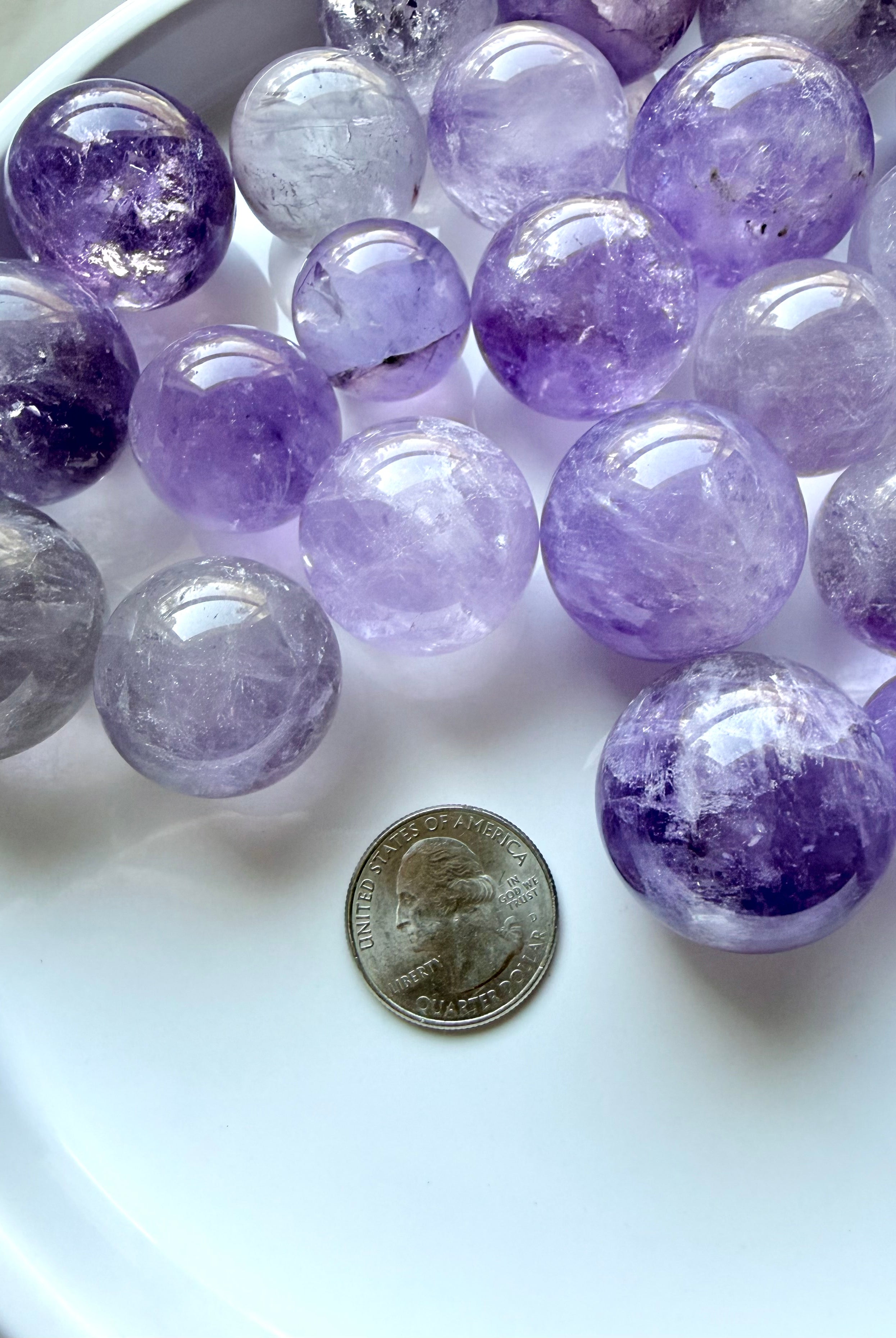 small amethyst crystal spheres with quarter for size reference mini smoky amethyst crystal balls in lavender and gray tones