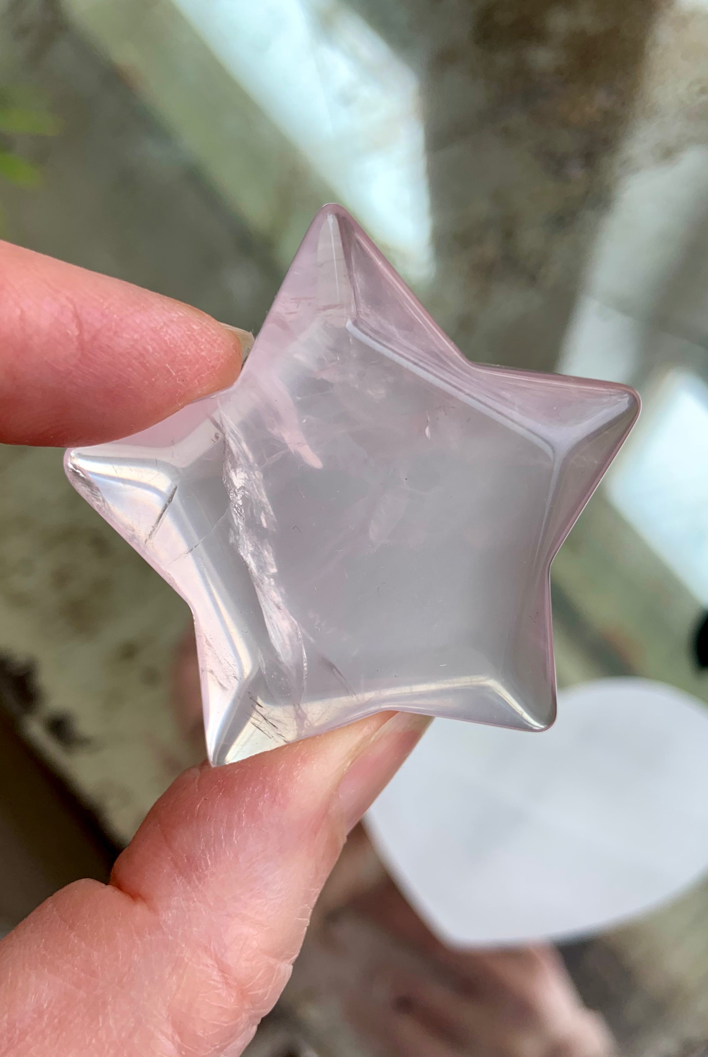 Polished Rose Quartz crystal star held up to light, displaying unique internal patterns and gentle pink tone — heart chakra healing stone from Mozambique.