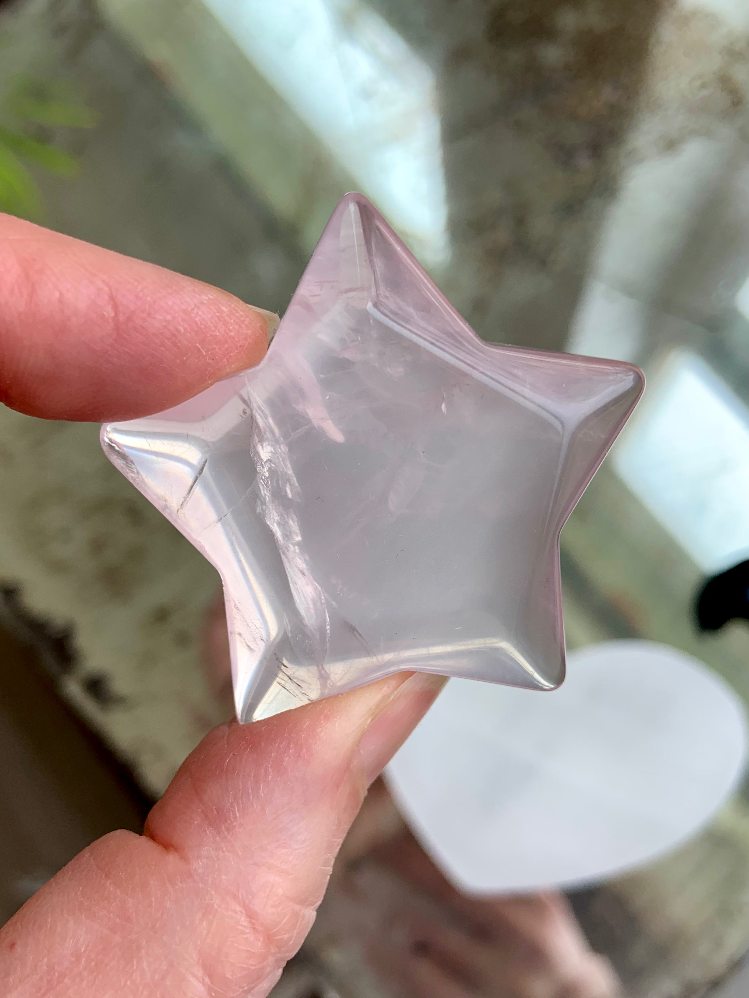 Polished Rose Quartz crystal star held up to light, displaying unique internal patterns and gentle pink tone — heart chakra healing stone from Mozambique.