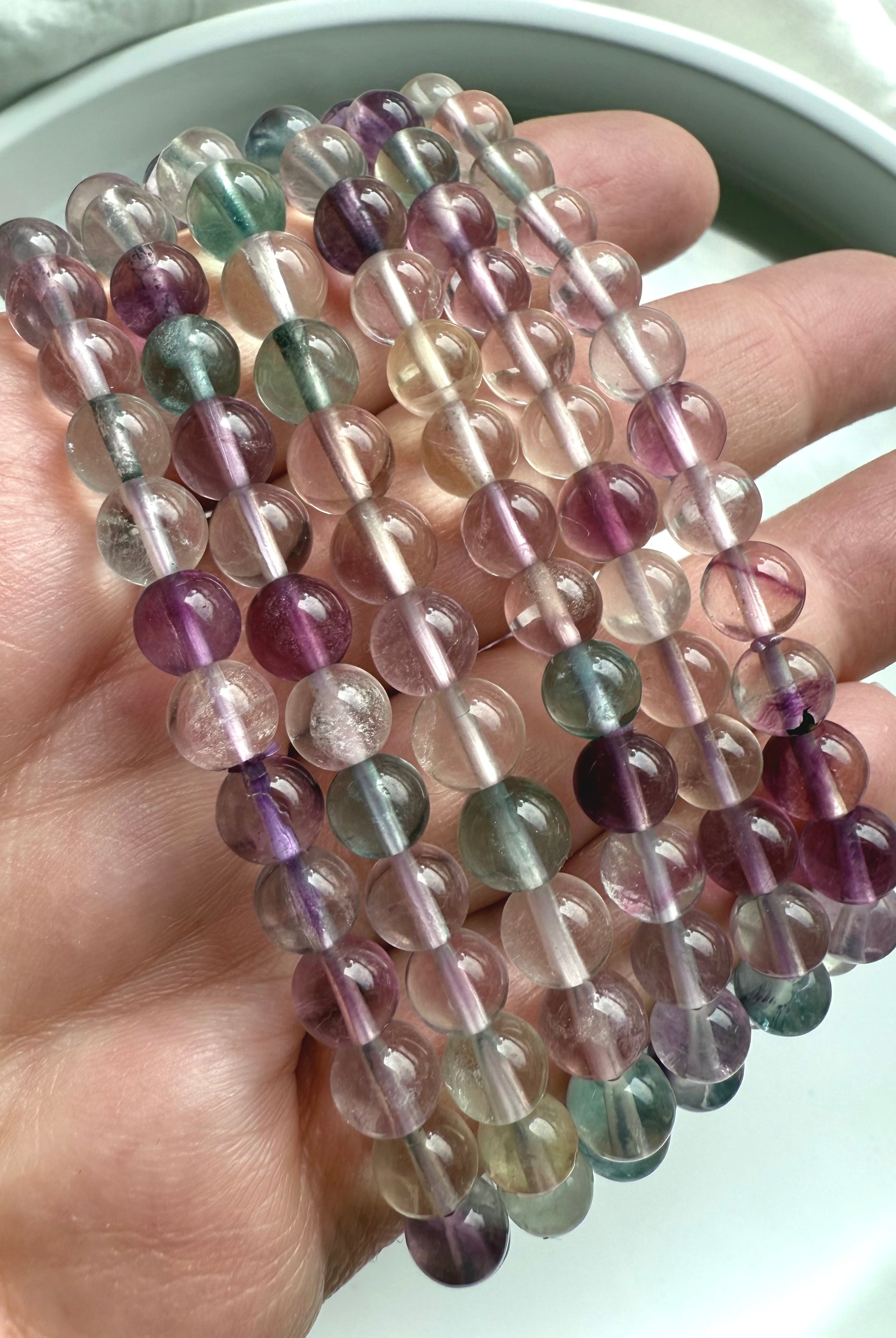 Close-up of high clarity fluorite crystal beads showing natural banding and rainbow color variation