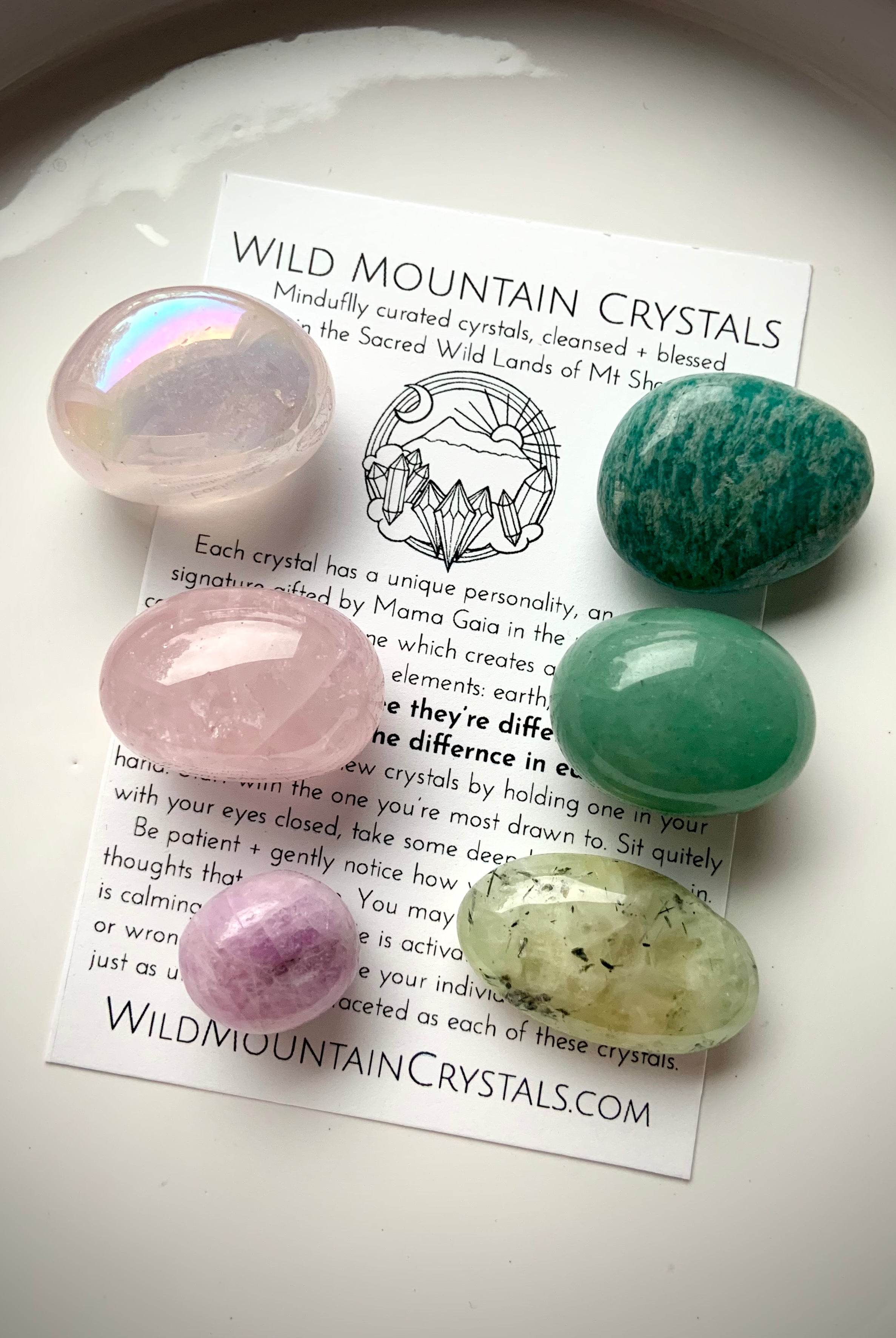 Heart Chakra crystal tumble set with 6 healing stones arranged on a card — pink on the left, green on the right. Includes aura rose quartz, rose quartz, kunzite, prehnite, green aventurine, and amazonite.