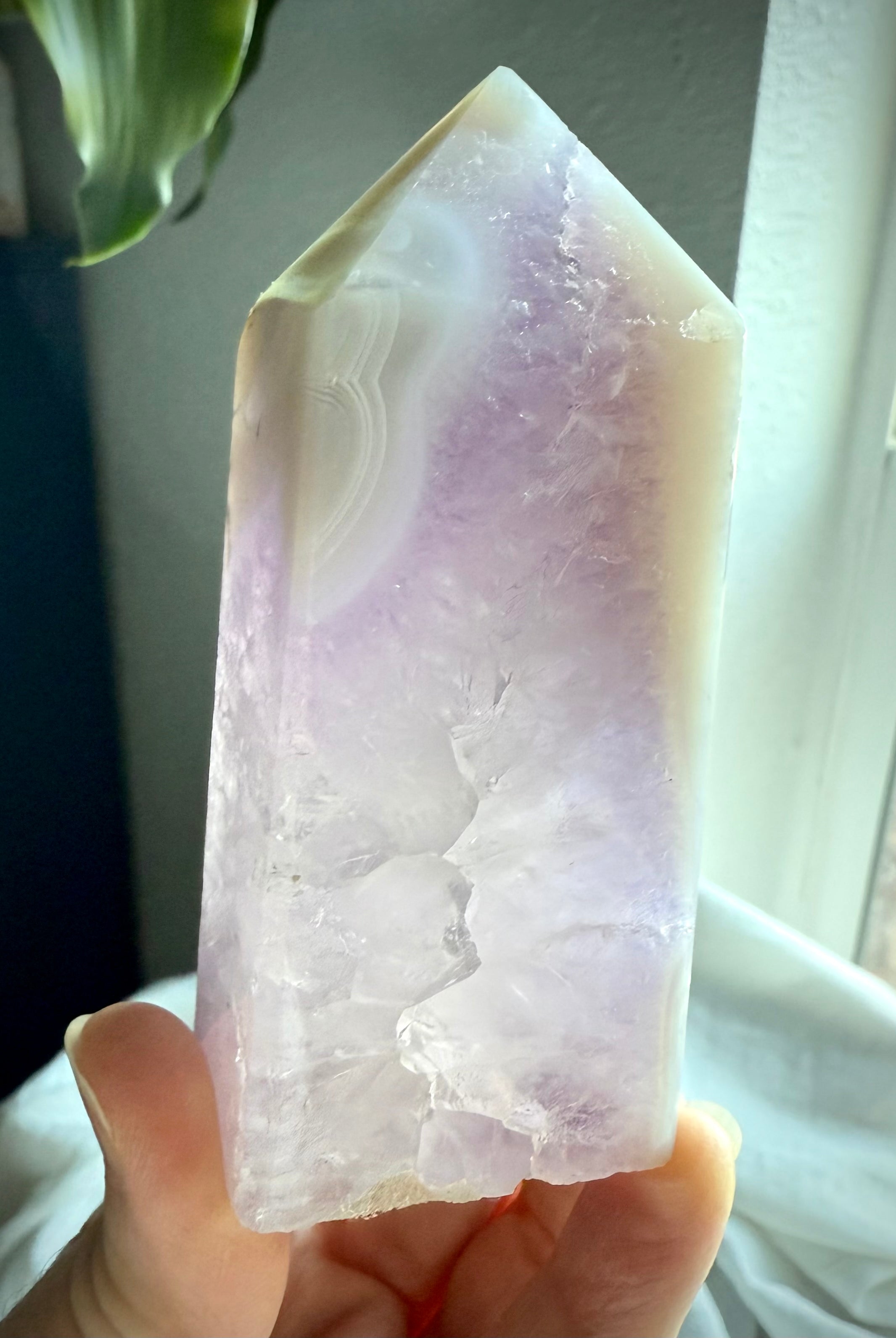 Backlit view of polished Amethyst and Agate Tower with quartz inclusion and soft purple hues