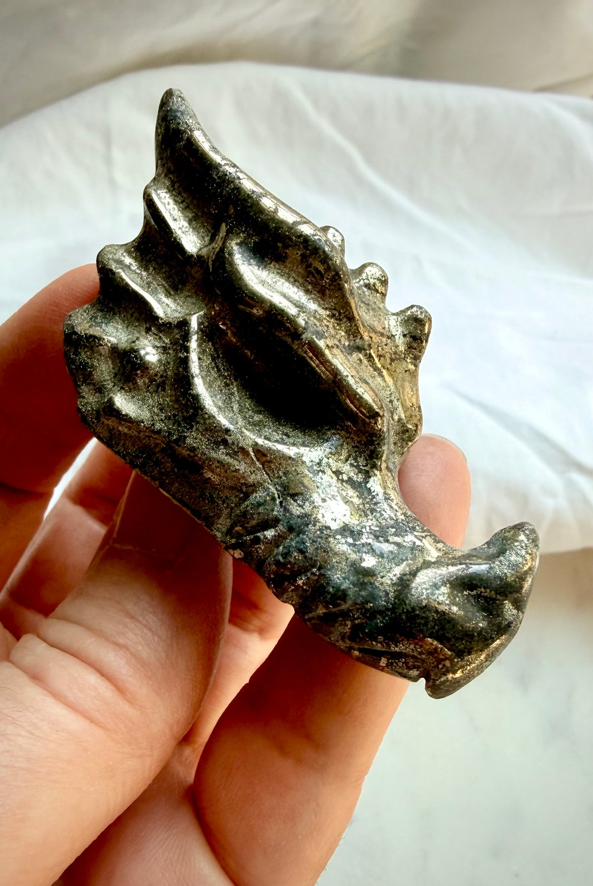 Pyrite dragon carving with antiqued metallic gold finish, intricate dragon head details, and natural mineral inclusions, held in hand