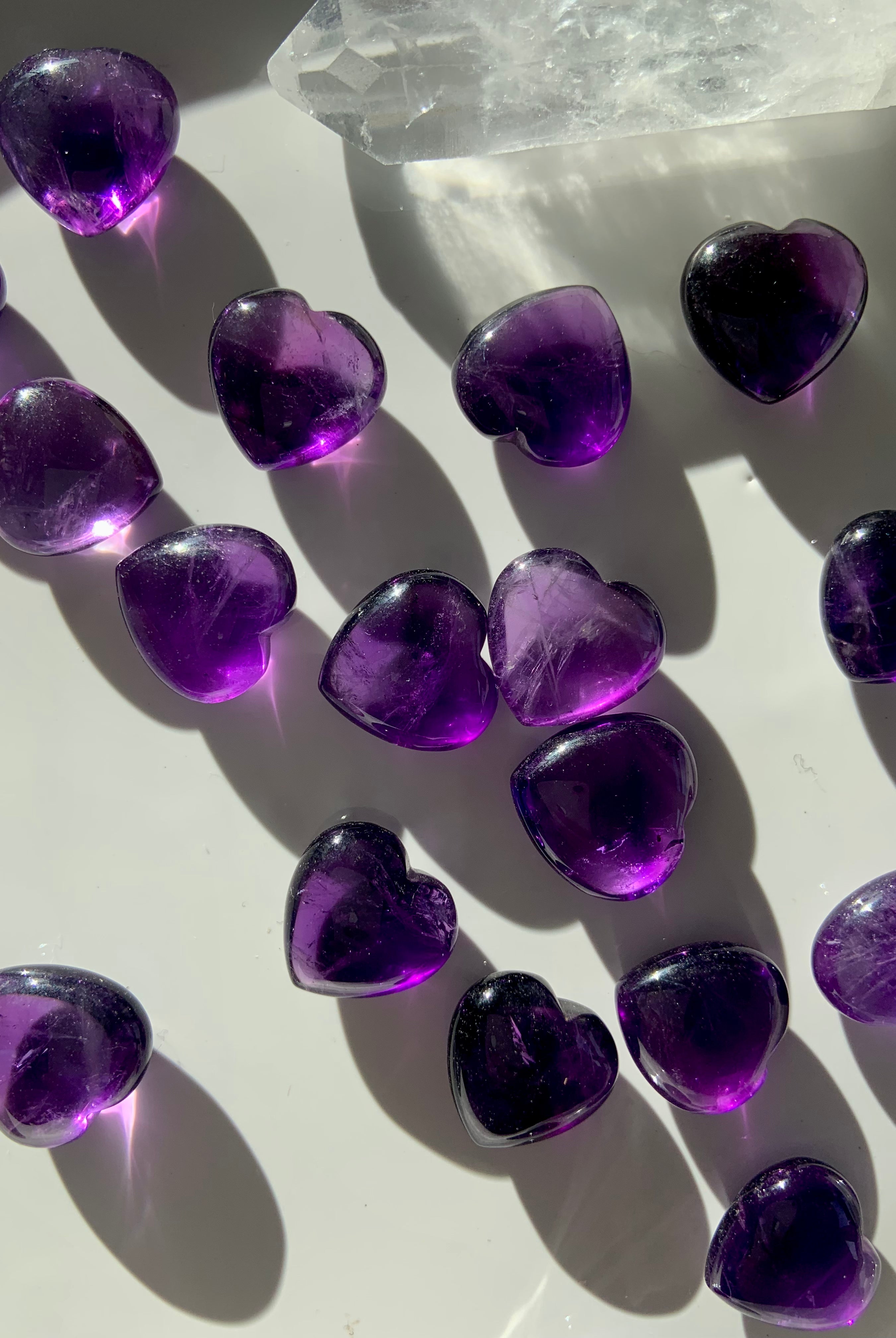 Gemmy Amethyst hearts with a quartz point on white — mini purple crystals for spiritual healing