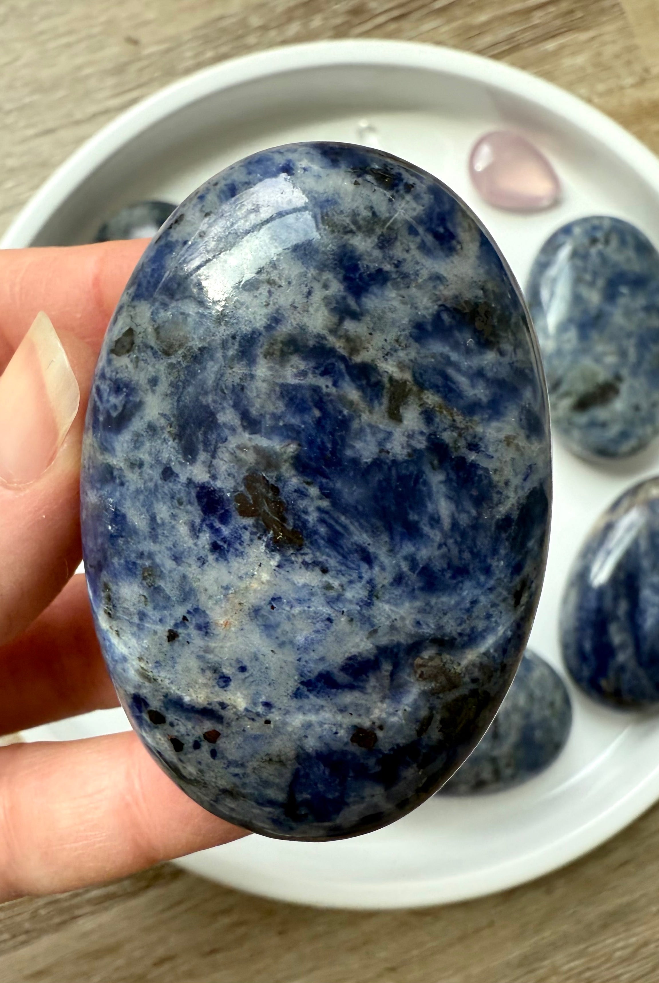 Close up picture of a high quality blue Sodalite Palm Stone held in my hand for scale