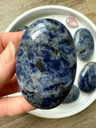 Close up picture of a high quality blue Sodalite Palm Stone held in my hand for scale