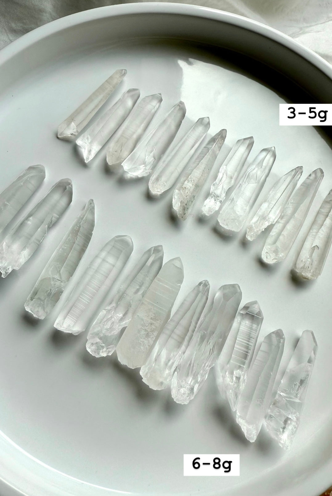 Lemurian Quartz Points displayed on a white plate with sizes labeled — authentic Brazilian crystals for energy healing & soul-level activation.