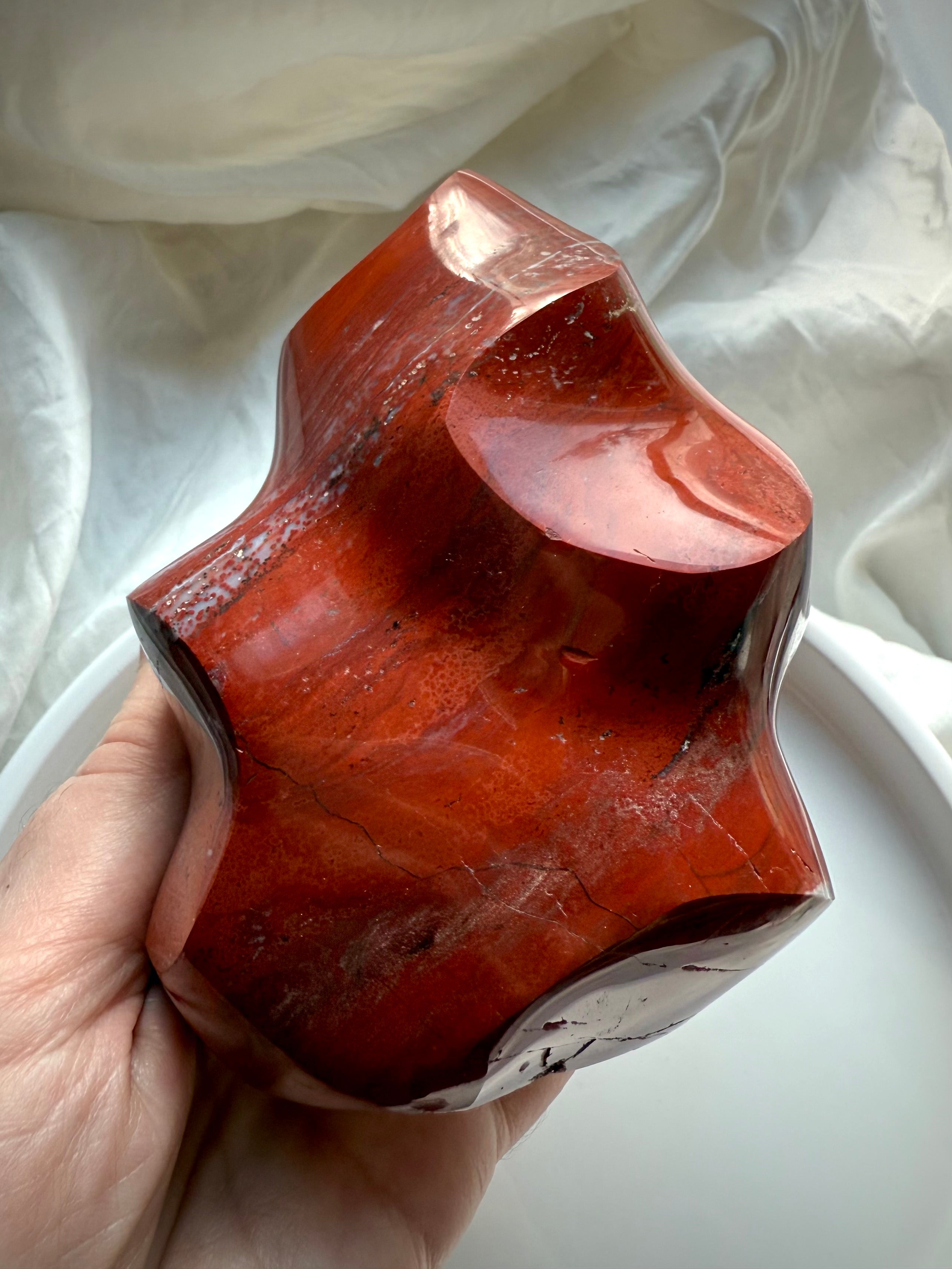Red Ocean Jasper flame freeform showing polished bands, earthy red tones, and natural patterning in soft natural light.