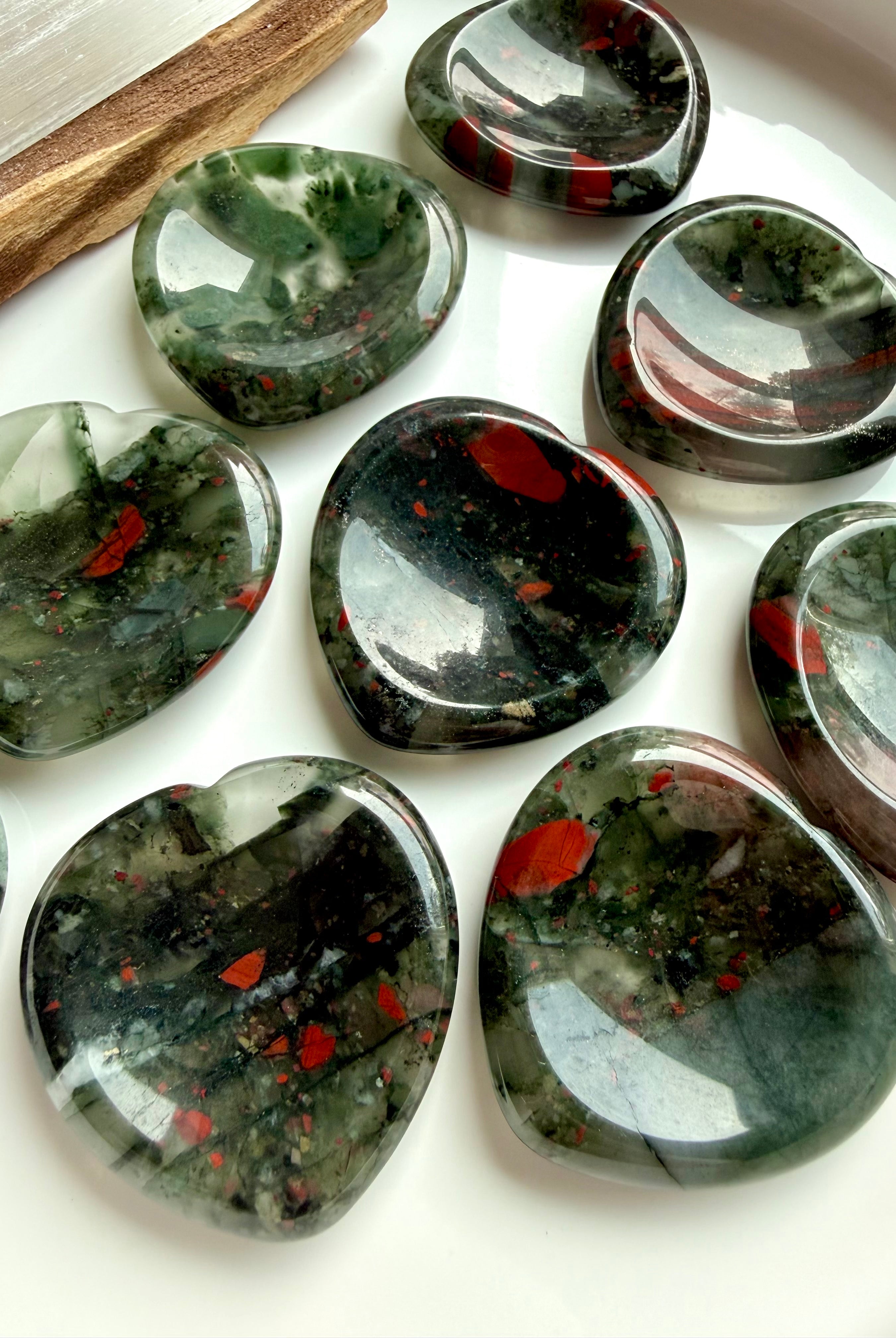 bloodstone heart worry stones with deep green base and red inclusions on marble, grounding crystal for strength stress relief and root chakra