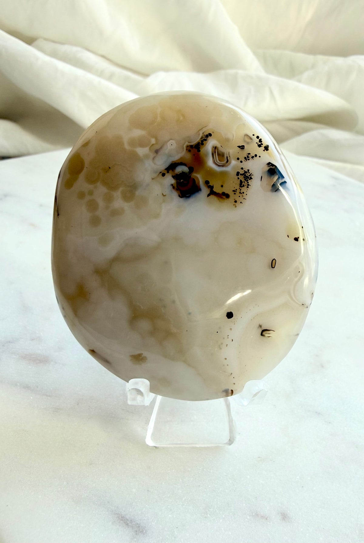 Dendritic Agate freeform shown on included stand, highlighting its naturally irregular shape, smooth polish and earthy inclusions