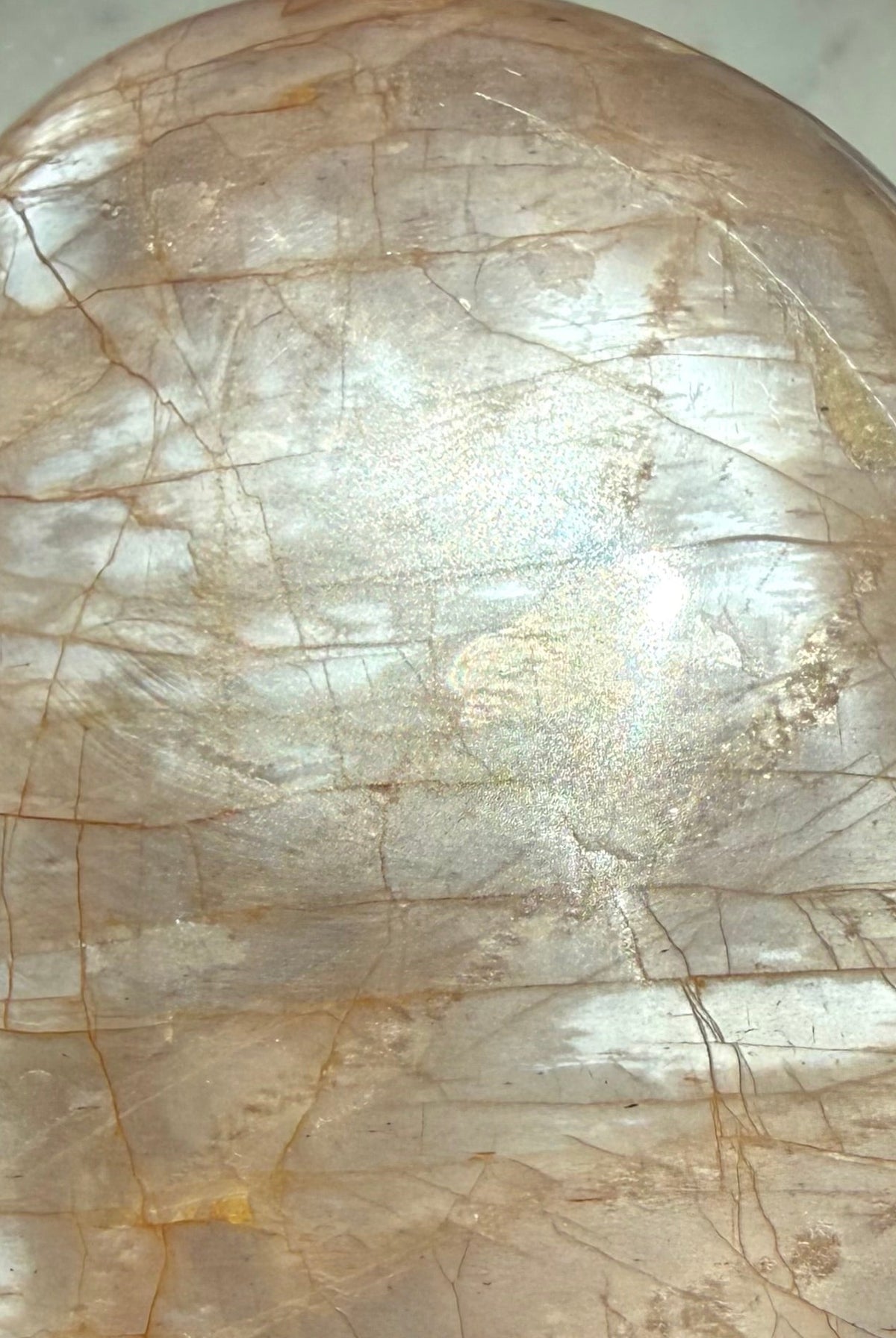 Close-up of Peach Moonstone freeform showing luminous silver flash, natural crack lines and warm peach orange coloring