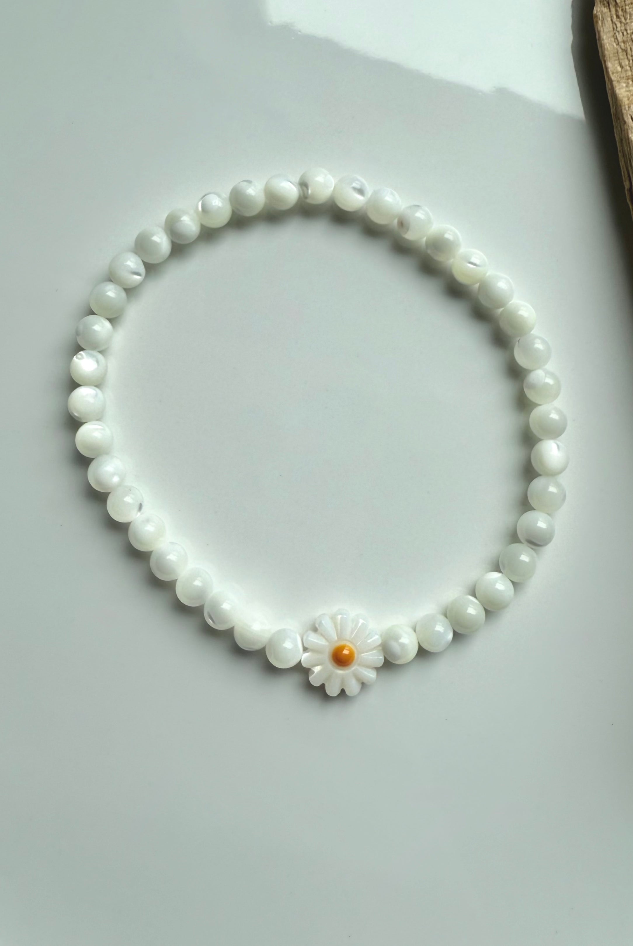 Single Mother of Pearl daisy bracelet styled in circle on white background – shell bead bracelet with flower focal bead