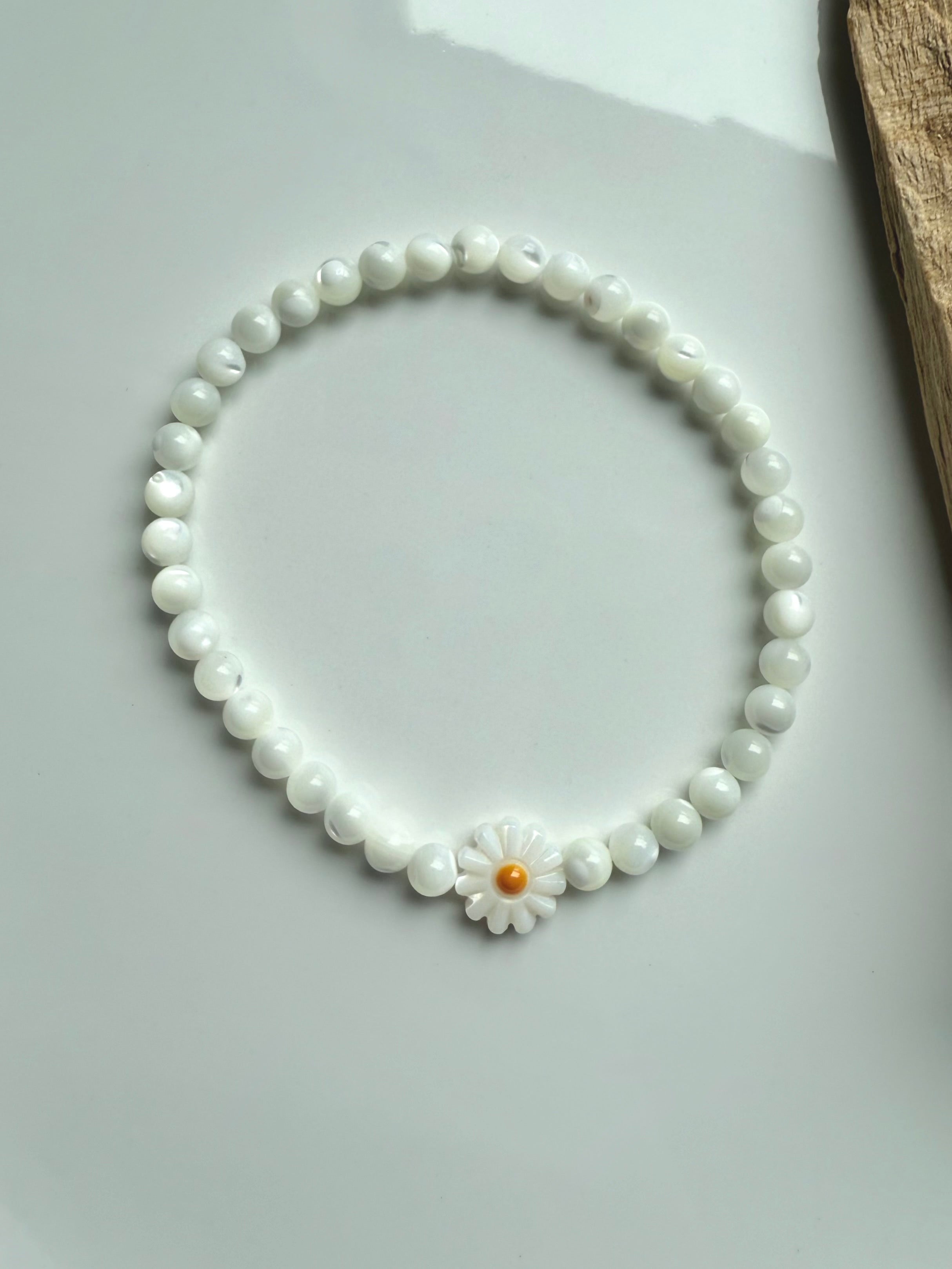Single Mother of Pearl daisy bracelet styled in circle on white background – shell bead bracelet with flower focal bead