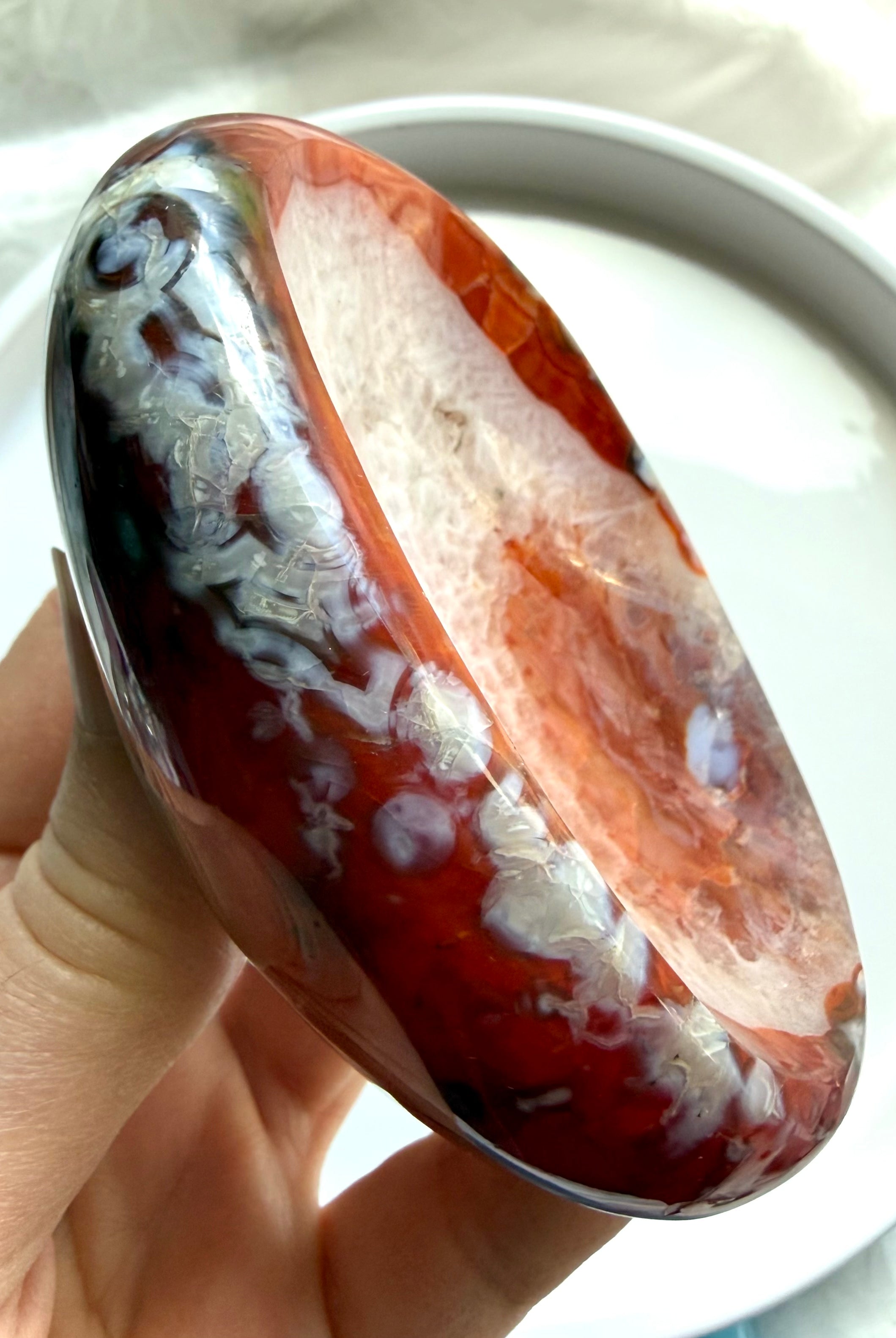 carnelian crystal bowl held in hand with white quartz druzy center and natural agate inclusions