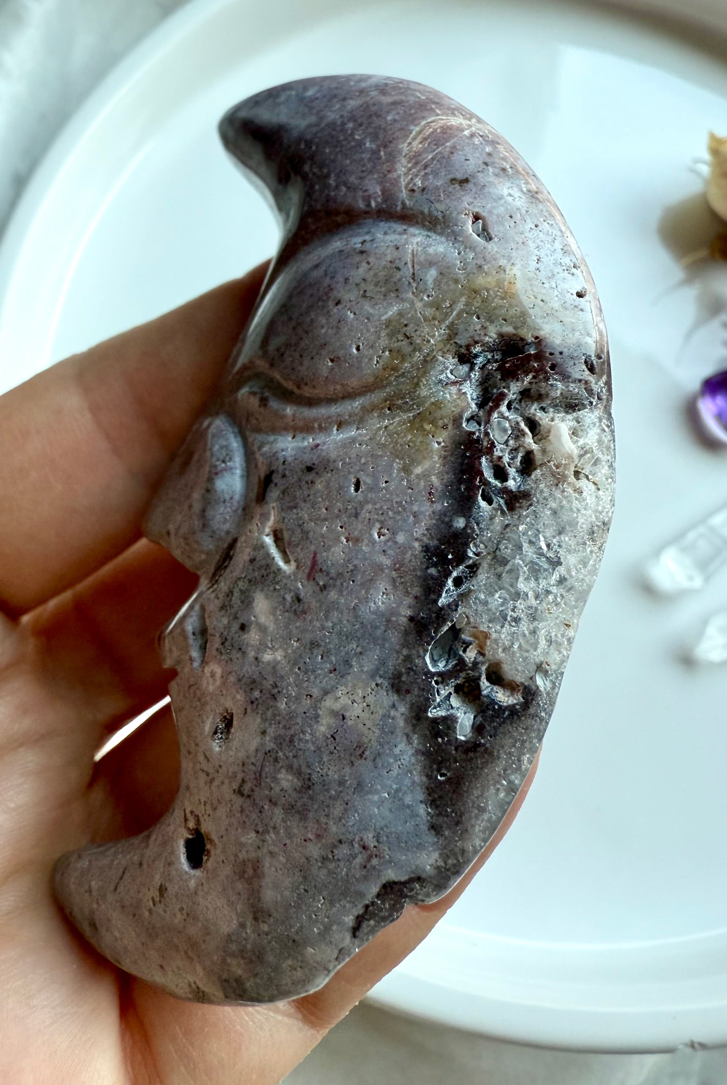 Close-up of Ocean Jasper moon face carving showing sparkling druzy pocket and stone texture.