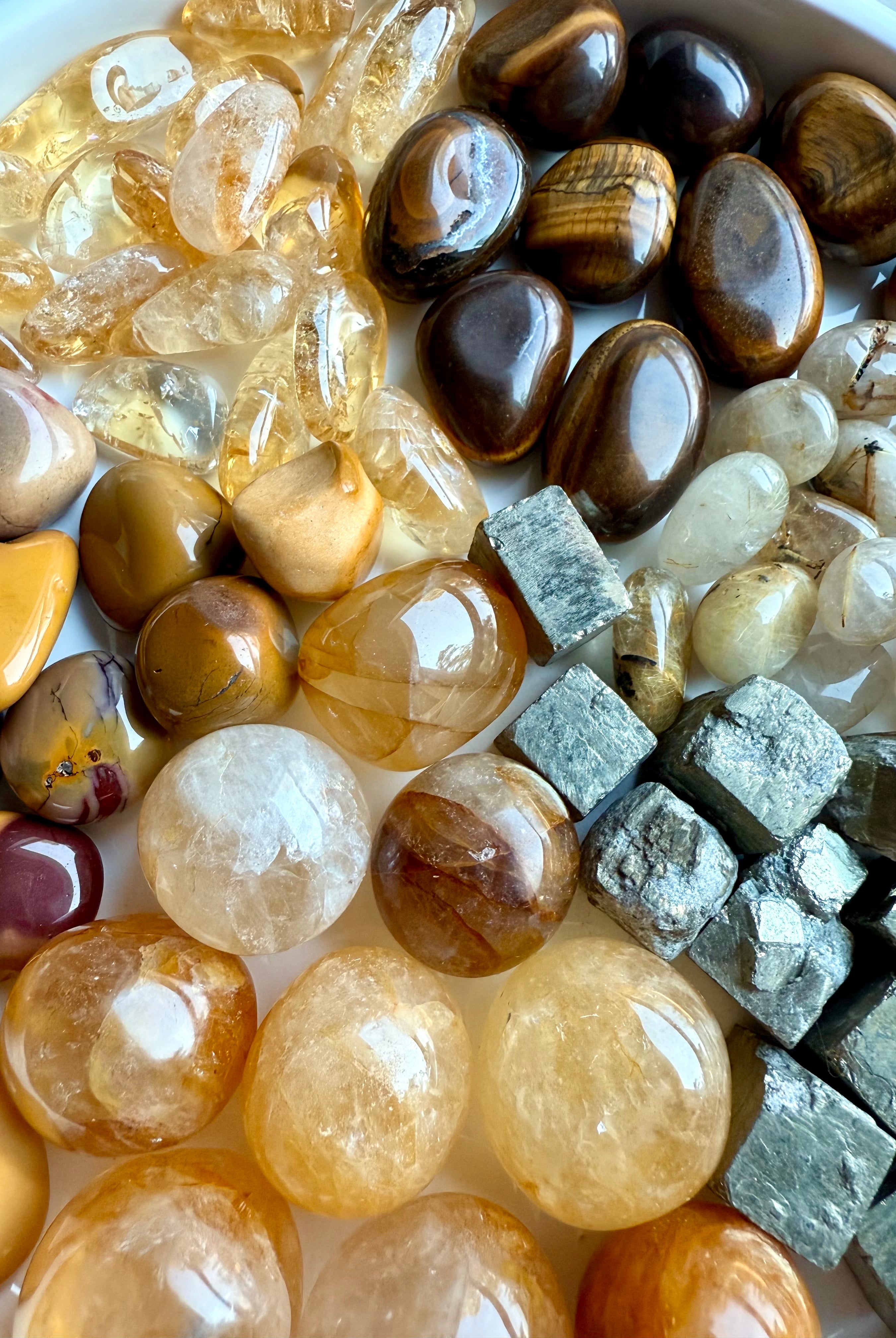 Close-up of segmented crystal pie layout — golden healer, citrine, golden rutile, tiger’s eye, yellow mookaite, and pyrite arranged in radiant abundance