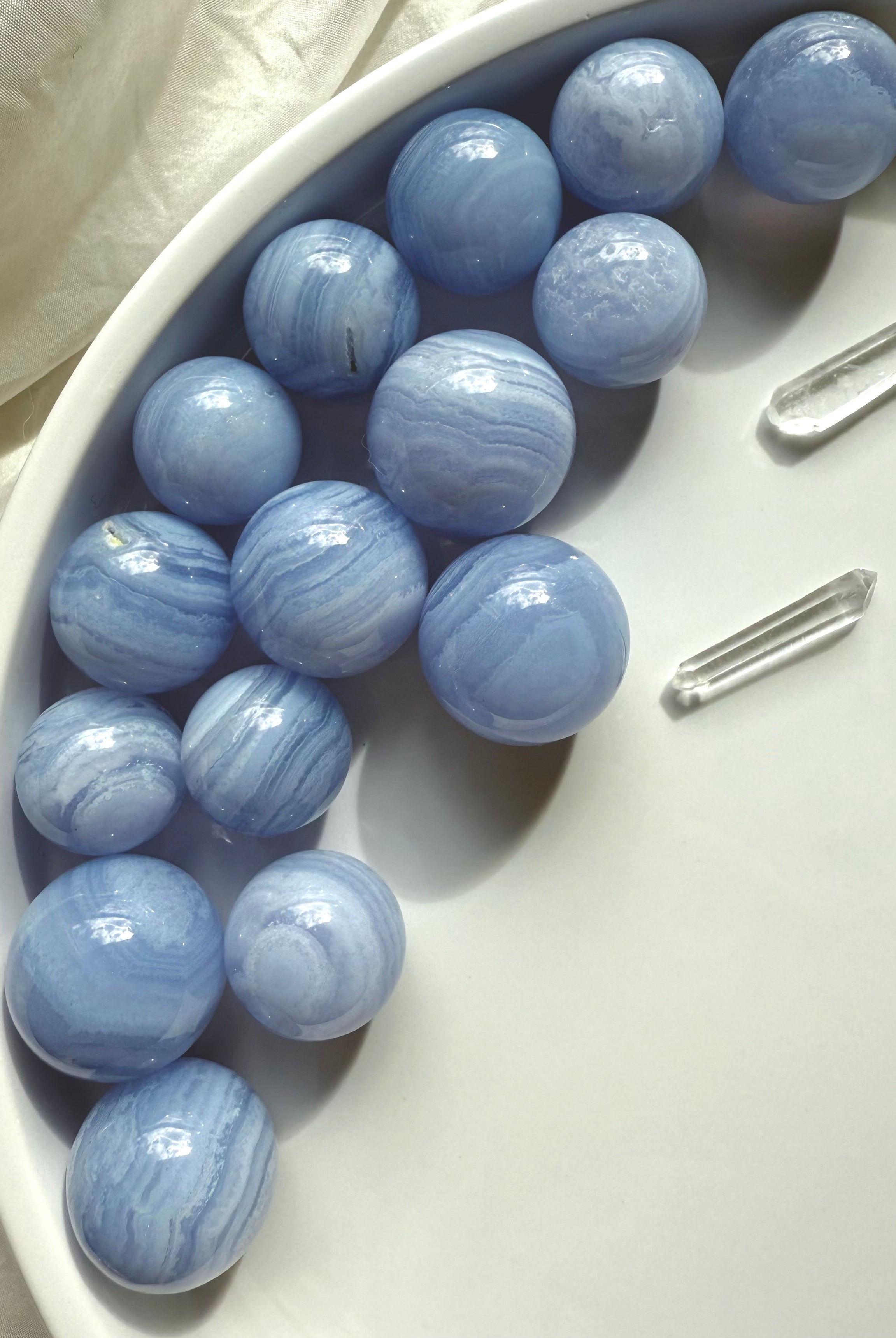 High quality mini Blue Lace Agate Spheres photographed on a white plate in natural light
